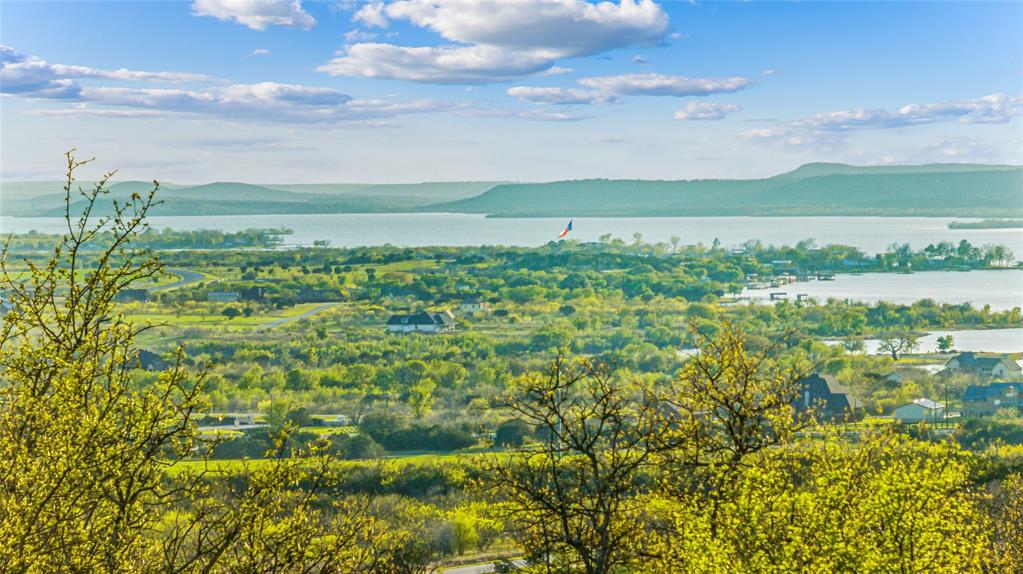Build your dream home or weekend escape on this beautiful two-acre cul-de-sac homesite in the desirable Hills Above Possum Kingdom Lake. Tucked within a gated northern Hill Country community, this property offers a peaceful, private setting highlighted by gorgeous valley views, serene views of Possum Kingdom Lake, and natural stone-lined trails that wind throughout the property.

The upper portion of the lot is relatively flat and provides an ideal building site perfect for a custom home designed to capture lake views, scenic sunsets, and the surrounding Hill Country landscape. Native trees, natural stone, and elevation changes create both character and privacy, offering a truly special homesite for those seeking space and natural beauty.

Water and electricity are available at the street, making the property ready for your future plans. There is no requirement to build immediately, allowing you to move at your own pace and select the builder that best fits your vision. CCRs require a minimum 2,500 square foot residence. When the time comes, the seller does have thoughtfully designed home plans available that may be customized if desired.

Lot ownership includes access to all neighborhood amenities, including boat storage, a community boat ramp and dock, clubhouse with pool and fitness center, fishing pond, lake access, picnic area with cabin, nature trails, and more than 20 miles of private gated roads, providing the perfect balance of lake recreation and quiet country living.

Enjoy the freedom of acreage living with resort-style amenities, breathtaking scenery, and the relaxed Possum Kingdom Lake lifestyle, all less than two hours from the DFW Metroplex.