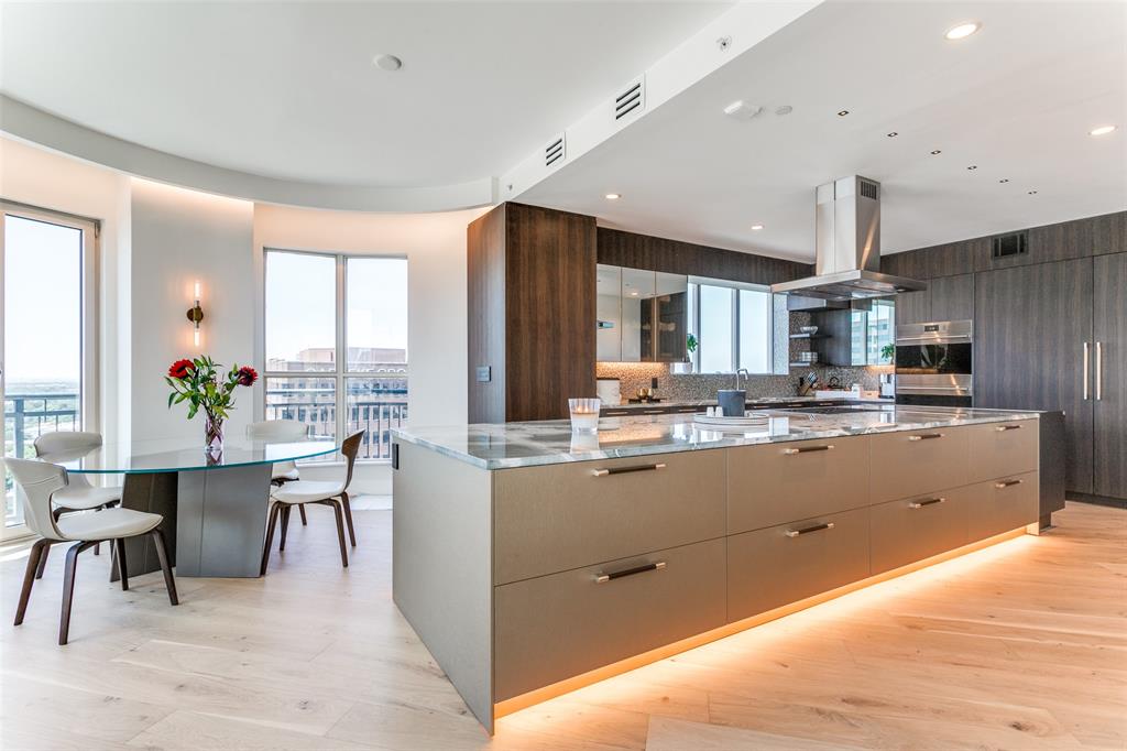 Contemporary home with stunning panoramic views of downtown, overlooking Arlington Hall and Turtle Creek Park. Experience breathtaking sunsets from this exquisite open floor plan with top-tier finishes, including 3 ensuite bedrooms, along with a separate office that could serve as a 4th bedroom. This flexible layout is enhanced by custom hardwoods and Ornare cabinetry. The kitchen showcases upper cabinets with reflective, mirrored glass, Subzero-Wolf appliances, including built-in refrigerator and freezer, flush-mount gas cooktop, microwave drawer, double ovens, and dual Asko dishwashers. The kitchen and wet bar exhibit 3cm Crystal Tiffany quartzite countertops, complemented by an ice maker and Sub-zero wine refrigerator. The Mayfair has every amenity for an upscale, urban lifestyle: full concierge, valet, fitness center, pool & gardens, sky club lounge, rooftop access, billiard & bar room, & business center. This home includes 5 assigned parking spaces and 2 storage units.