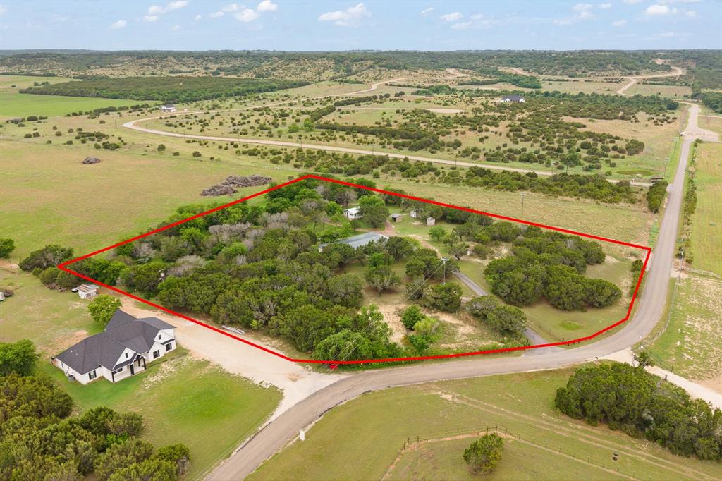 Welcome to your own slice of Texas serenity at 6677 CR 2008 in Glen Rose! Nestled on 4.22 beautifully wooded acres, this versatile property offers the perfect blend of privacy, functionality, and opportunity. The main home is a spacious doublewide with 3 bedrooms, 2bathrooms, and the largest wrap around porch you have ever seen. The separate accessory unit opens the door for additional income, an Airbnb setup, or the perfect mother-in-law suite. The accessory unit is 811 sq ft 2 bedrooms, 1 bath with separate electric meter. The homestead has a shared well between the two dwellings. and each have their own meter. 
Step outside and enjoy the peace and quiet of country living with a fully fenced property—ideal for pets, kids, or simply enjoying your space without compromise. A private water well keeps things efficient, and two electric meters provide flexibility for multi-generational living or rental potential. Safety and practicality are covered with a storm shelter, giving you peace of mind during those unpredictable Texas storms. Another unique feature is this rural home has natural gas available. It is also surrounded by mature trees, so that the property feels like your own private retreat while still being close to everything Glen Rose has to offer. Whether you’re looking for a homestead, an investment opportunity, or a place to bring the whole family together—this one checks all the boxes. Drawing of lot lines are approximate. Survey will determine final lot lines.