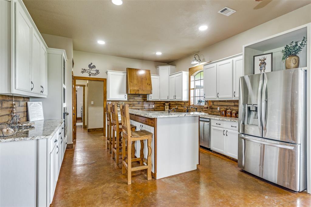 One of a kind property!  AG EXEMPT! NO CITY TAXES!  Custom farmhouse thoughtfully positioned on 32 acres in Justin.  The main house has 3655 Sq Ft and the guest house has 1200 sq ft.  As you enter you'll see the large great room with a corner stone fireplace, a spacious dining area & open kitchen. There is a private study with French doors.  The kitchen features two copper sinks, a breakfast bar & an abundance of cabinet & counter space. There is a large game room that is a fun place to  hang out with the family & friends. The primary bedroom is split for privacy. HUGE utility room and mudroom loaded with cabinets & storage.  There is a 155 sq ft solid steel safe room with a solid steel door that is fireproof.  The detached guest quarters offers a kitchen, living area, 2 BRS, 1.5 baths & is ADA compliant. The 40 x 50 workshop has a bath & exterior hook up for an RV.  Gated entrance, fully fenced with cross fencing & smaller pastures for your animals, 6 working pens with water plumbed to each; Water well; & 2 ponds! Bring your horses or livestock! Trade traffic for sunsets! This property has so much to offer!