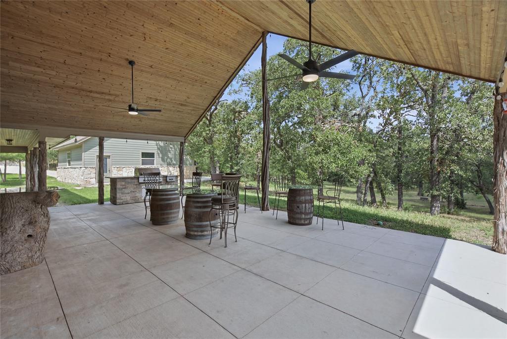 Nestled on approximately 14 + or - acres and tucked away behind a private gated road, this truly unique 4-bedroom, 3-bath custom home is overflowing with character and offers the perfect blend of rustic charm, modern comfort, and peaceful country living. Currently AG exempt, the property provides both privacy and functionality while showcasing beautiful natural surroundings and abundant wildlife.
From the moment you enter through the custom Durango front door, you'll be captivated by the home's distinctive design and warm log-home ambiance. Exposed wood walls, soaring vaulted ceilings, and exceptional craftsmanship create a one-of-a-kind retreat that feels both grand and inviting. Every detail has been thoughtfully designed to highlight the home's unique personality and timeless appeal.
The open-concept floor plan is ideal for both entertaining and everyday living, featuring a spacious living area anchored by a massive stone fireplace that serves as the heart of the home. The kitchen is beautifully appointed with granite countertops, a unique marble sink, and ample workspace, all flowing seamlessly into the living areas. Open-cell foam insulation enhances energy efficiency and year-round comfort.
Step outside to the expansive covered back porch, where grand vaulted ceilings and stunning tongue-and-groove woodwork create an impressive outdoor living space. Whether hosting family and friends, enjoying a quiet evening, or watching deer and other wildlife roam the property, this porch offers the perfect setting to take in the beauty of the surrounding acreage.
Combining generous living spaces, remarkable craftsmanship, and a character-rich design rarely found in today's market, this exceptional property is a rare opportunity to own a truly special piece of Texas countryside.