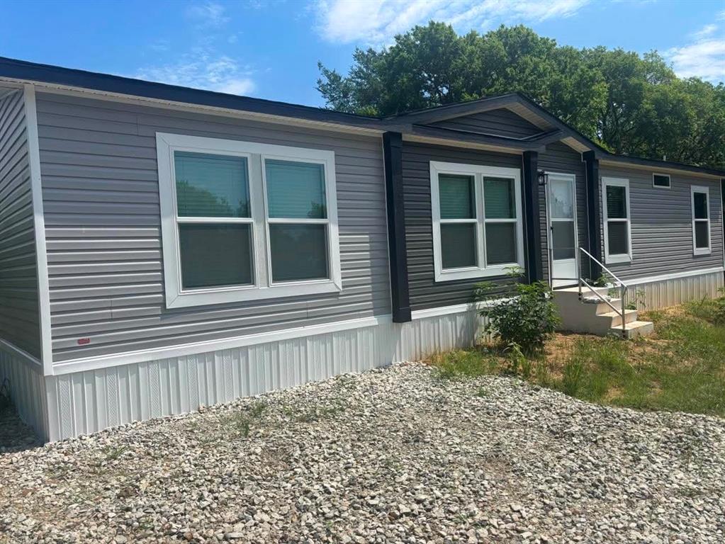 USDA Eligible!! You will be absolutely in awe seeing this brand new doublewide built by Clayton Homes sitting on .60 ac. already approved for fha!!! Never lived in and is waiting for new owner. This beauty is a 3br 2 bth with a huge kitchen with farm style sink and big island.  Brand new appliances including a fridge. Utiltiy room is separate for full size washer n dryer. Living area has built in fp with blower. You can physically walk the property and see the lake at the end.  Beautiful trees are there but could be cleared to have a perfect view of lake. If you're looking for a peaceful sitting place this is for you.  Hurry before it's too late. Buyer will need to obtain survey.