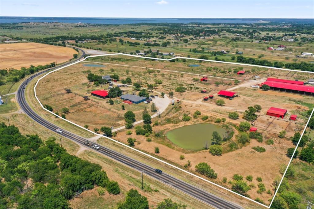 48.5-acre ranch on FM 2164 offering expansive views, multiple residences, and full equestrian facilities. This property is ideal for private use, boarding, or training operations.

Residences Total 5,413+ Sq Ft: Blue Home: Over 2,500 sq ft with 4 bedroom, 3.5 bathrooms.
Mobile Home: 1,510 sq ft open floor plan with 3 bedroom, 2 bathroom White House: 1,410 sq ft with 3 bedroom, 2 bathroom.

Equestrian Facilities:
110x220 covered arena 
Show Barn is 68x230: Spray-foam insulated with 27—12x12 stalls, 3 wash racks, tack room, feed room, office, and 2 restrooms.
Hay Barn with Mare Motel: Hay storage, 7, 10x10 stalls, tack room, and storage loft.
Additional Storage Barn: Overhang, tool room, and 6 stalls located between two homes.
Covered Round Ped

Land & Infrastructure:
3 large pastures, 2 smaller pastures, 5 turnouts with shade cloth, 3 paddocks, plus 5 paddocks with shelters.
2 wells, 3 ponds, and 2 gated entries.
A rare opportunity to own a fully equipped ranch with ample space, quality facilities, and flexibility for a variety of uses. Schedule your showing today.
