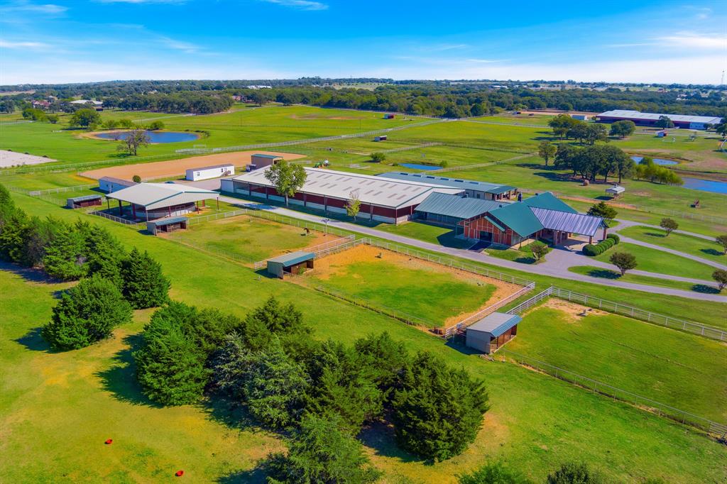 Welcome to Liberty Ranch, an exquisite horse training facility that exemplifies fine country living in a highly desirable location. Set amidst a tapestry of picturesque horse ranches and estates, this remarkable property is located just minutes from the stunning Lake Ray Roberts and Isle Du Boise State Park.  The exceptional equestrian facilities offer a first-class show barn features 12 stalls, an office, full bath, half bath, tack room, lab, stocks, wash rack, Nelson waters, stable comfort mats, and grooming stalls. Adjacent to the show barn is an expansive 100 x 200 covered arena, ideal for year-round training. The second barn offers an additional 20 stalls, tack room, wash rack, stable comfort mats, & auto waterers. Additional amenities include four paddocks with loafing sheds, a covered round pen, and 150 x 315 outdoor riding arena, complemented by several spacious pastures & two mobile homes for staff accommodation. Embrace the scenic landscape adorned with scattered trees, four tranquil ponds, rich sandy loam soil, and pipe and cable fencing, all accessed via paved roads and two inviting gated entrances. Conveniently situated just one hour from DFW International Airport and metroplex Liberty Ranch offers a premier opportunity for any equestrian business. Ag exempt.