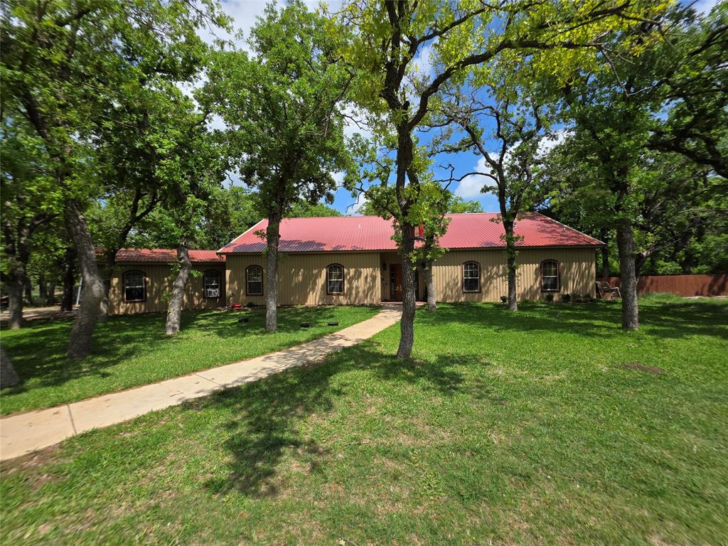Folks! If you are looking for a beautiful property in the country to call your own, this is the one for you! This property is a very nice place, one to be proud of! This ranchette has a lot to offer. When you enter the property, you will drive up the long, tree lined driveway, to a very nice all metal 3100 sf (per seller) 3 bd 2.5 bth home with loft. Home has great curb appeal. Home offers an open floor plan, with separate dining room, and utility room. There is a nice large front yard and back yard, with a sprinkler system to keep yard looking nice. There is a nice, large back porch, to relax on, after a hard days work. Other improvements include a nice 2100 sf (per CAD) all metal workshop, with an attached 900 sf, 1 bd 1 bth apartment. Other improvements include a 50 x 17 RV shed, and 630 sf 3 sided shed. The land is mostly wooded with nice large Post Oak, Blackjack Oak, Mesquite, Cottonwood, and other brush and browse for the abundant wildlife. Wildlife consist of Deer, Dove, Turkey, Hogs, and varmints. There is 1 nice tank, and 1 water well in place, plus county water to home. Ag exemption is in place. There is lots of fantastic native grasses, so you can run a few head of livestock, if so choose. Don't miss out on this gem of a ranchette!