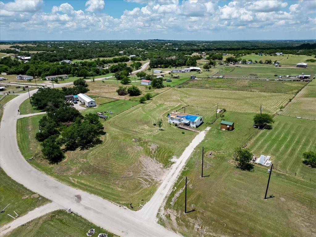 MAKE OFFER! Rare opportunity to own 2.57 acres in a peaceful country setting within Springtown ISD. While the existing mobile home sustained tornado damage and is not considered habitable, the true value lies in the land and improvements already in place. This large, level, fully fenced property offers an ideal homesite with co-op water, electricity, and an aerobic septic system already installed—saving time and expense for future development. Whether you're looking to build a new home, place a new manufactured home, or invest in acreage with utilities in place, this property provides endless potential. Enjoy the freedom of country living with plenty of room for livestock, equipment, gardens, or recreational use, all while being conveniently located near town amenities.