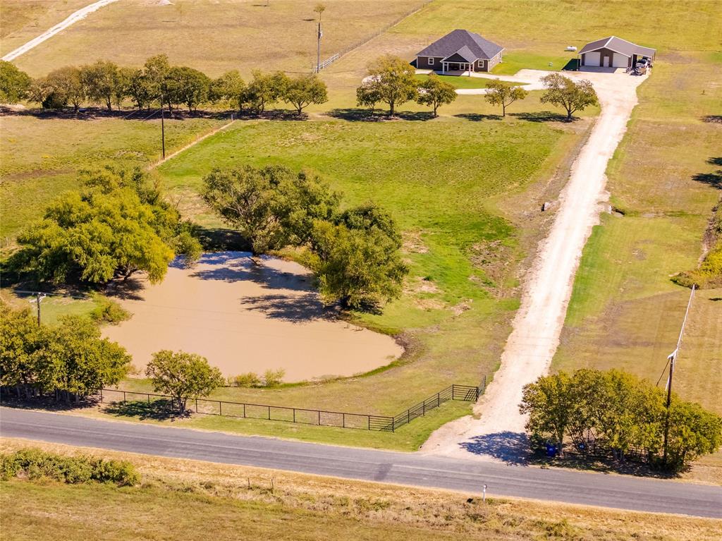 MOTIVATED SELLER! This 13.53-acre ag exempt property offers a rare combination of modern construction and productive land use.  Built in 2021, the 4-bedroom, 3 bath home includes 2 primary bedrooms, a well-appointed kitchen with granite surfaces, farmhouse sink, and center island, and a functional layout designed for everyday living.  The acreage is currently in agricultural production with an established hay crop, providing both tax advantages and income potential.  A 35' x 30' insulated shop with water and heat expands the property's utility for equipment storage, or workshop needs.  Additional highlights include a scenic pond and ample space suitable for livestock, recreation or future improvements.  Located just 10 minutes from Whitesboro, 20 minutes from Sherman, and under an hour from the Metroplex, this property delivers versatility, privacy, and long-term value.