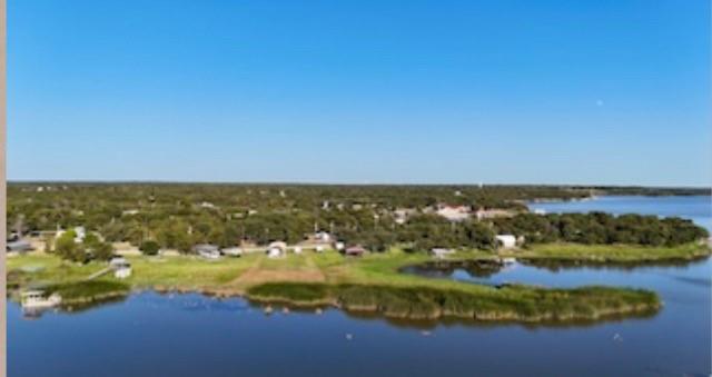 Waterfront lots x 2 on charming Lake Brownwood! two breathtaking lots with an RV with beautiful wood porch. Great access to the water. Beautiful porch great for sitting in peace and watching the sun set over Lake Brownwood. Neighborhood is peaceful and great for RECREATION or YOUR LAKE HOUSE providng peace and a sense of privacy for great quality of life. You have access to the public dock, boat ramp, POOL, and showers along with dump station. You can keep the existing RV, replace with another one or build a home!. Lots has a large RV cover for safety and can fit diverse sizes. Property includes a large, strong wood picnic table, fire pit with wood stack and shed for storage. Come check it out and see yourselves loving your lake life!