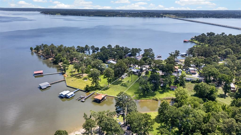 From the street view, through the home and backyard to the boathouse overlooking Lake Palestine, this property is just what you would want your Lakehouse to be. Fully updated including an addition, updated boathouse, plumbing, paint, roof & gutters, windows, kitchen, bathrooms, flooring, insulation, deck and new asphalt drive all in the last several years. (Refer to Updates & Upgrades sheet in documents tab). The location in Brierwood Bay is perfect being on the peninsula near Panorama Park. Two-slip boathouse with 2 lifts and a water depth of 4'. Extensive professional landscaping front and back. Two-car covered carport and 3 sizable sheds in the backyard allow for all of your toys, wood shop and 'she' shed. Located on 2 lots with a large flat backyard, a lovely front porch and spacious covered back deck with an outdoor kitchen. There is plenty of space outdoors to enjoy.