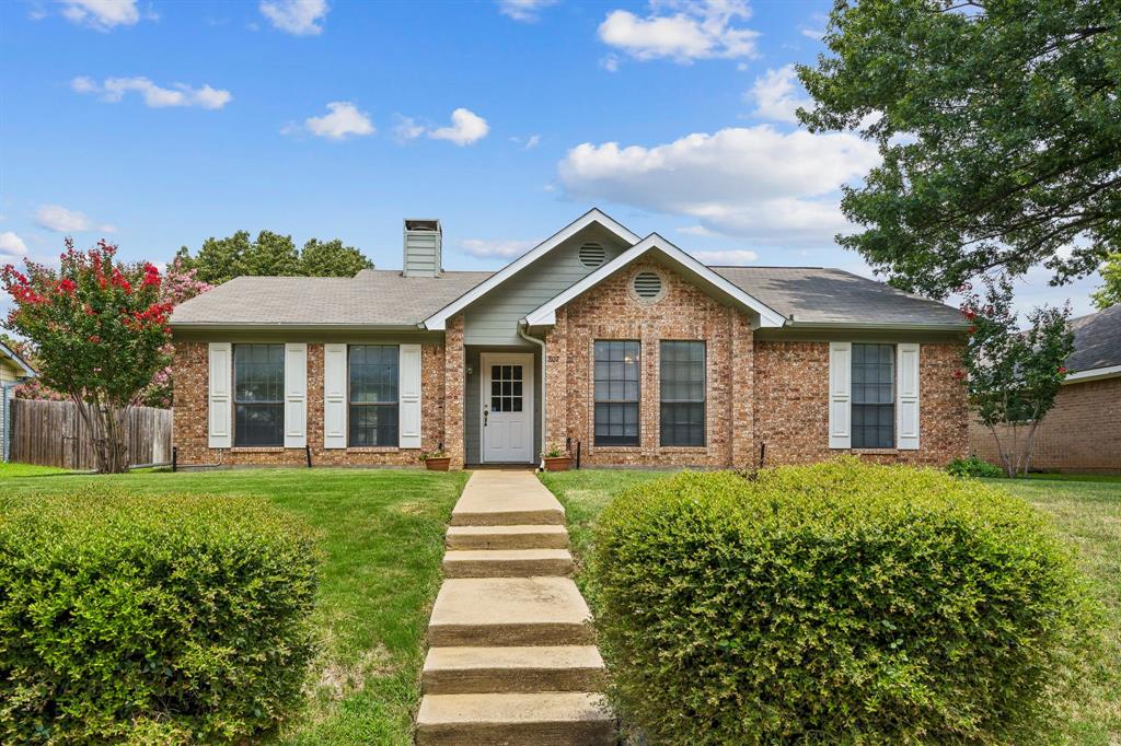 Welcome Home to 807 Blue Oak Drive.  This charming 3-bedroom, 2-bath, 2-car garage home is nestled in the established and desirable Timbercreek Estates neighborhood.  Recent updates include newly installed laminate flooring in the living and dining areas, neutral carpeting in all three bedrooms, and a freshly painted exterior.  Step inside to a spacious living room featuring a unique wraparound fireplace that can be enjoyed from both the living and dining spaces.  A convenient pass-through from the kitchen to the dining room creates an open, connected feeling that's perfect for everyday living and entertaining.  Natural light fills the living and dining areas through windows overlooking the front, side, and back yards.  The kitchen offers stainless steel appliances, a pantry, and a window above the sink with a pleasant view of the backyard.  Adjacent to the kitchen, the breakfast nook provides a cozy dining space and includes a convenient laundry closet with additional storage shelves tucked behind bi-fold doors.  The primary suite features a large walk-in closet and an ensuite bath with dual sinks and a tub-shower combination.  Two bright secondary bedrooms and a full hall bath complete the interior.  Step outside to the charming covered patio, the perfect spot to enjoy your morning coffee or tea, or relax at the end of the day while overlooking the spacious backyard. The backyard includes a sizable storage shed, offering plenty of room for tools, hobbies, or seasonal items.  All of this is ideally located near Central Park, shopping, dining, DFW Airport, and major highways, including Hwy 121 and I-35.  This home combines comfort, convenience, and value in one attractive package.  Don't miss the opportunity to make this wonderful home your own!