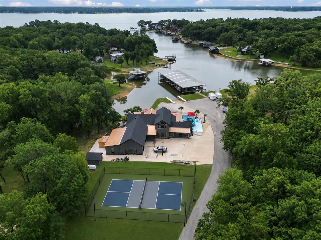 Experience luxury lakefront living at its finest in this extraordinary Cedar Creek Lake retreat situated on approximately 1.03 acres with expansive shoreline views. Designed for entertaining on a grand scale, this custom waterfront estate blends modern luxury, resort-style amenities, and unforgettable indoor-outdoor living. From the striking architectural design and oversized concrete approach to the copper-toned roofing accents and expansive garage space, every detail was thoughtfully curated to create a true destination property. Inside, soaring vaulted ceilings, dramatic custom wood accents, designer lighting, polished luxury flooring, and walls of glass frame breathtaking water views throughout the home. The open-concept living area flows seamlessly into a chef-inspired kitchen featuring oversized islands, premium appliances, double ovens, wine storage, custom cabinetry, and expansive entertaining space ideal for hosting large gatherings or executive retreats. A statement spiral staircase and elevated architectural finishes add to the home’s distinctive luxury appeal. 

Step outside to a private resort atmosphere complete with a custom pool and slide, 8 person hot tub with jets, 8 person sauna, tanning ledges, expansive decking, covered outdoor living areas, retractable screens, outdoor kitchen, mounted TVs, Ferrari speaker sound system, sauna, and multiple lounge spaces overlooking the water. Additional highlights include three boat slips, oversized garage capacity, upgraded efficiency systems, premium doors and windows, spray foam insulation throughout, generator-ready infrastructure, and dedicated fitness space. Whether envisioned as a luxury vacation home, executive retreat, corporate getaway, multi-generational estate, or premier short-term rental investment, this one-of-a-kind waterfront property delivers an unmatched lifestyle on Cedar Creek Lake.