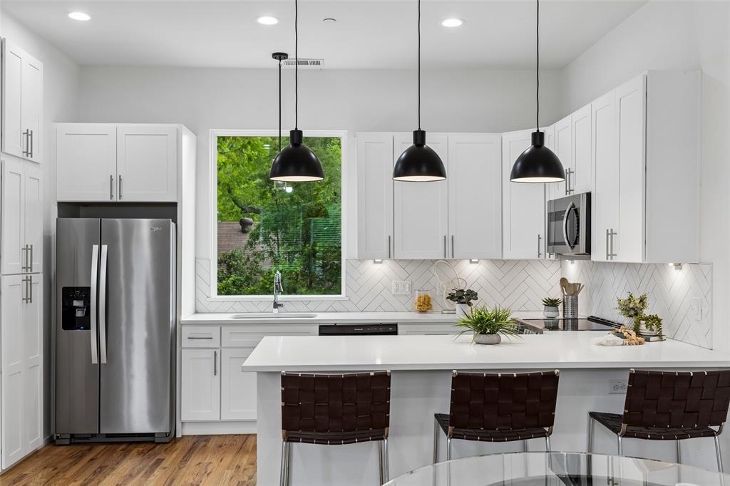 Built in 2022, 5647 Live Oak offers a rare opportunity to own nearly new construction in the heart of East Dallas—an increasingly hard-to-find advantage among the area's predominantly older housing inventory. Located minutes from Lakewood & Lower Greenville, this three-story townhome-style condo combines modern design, energy-efficient construction, and low-maintenance living in one of Dallas' most connected neighborhoods. Inside, real hardwood floors, abundant natural light, & open-concept layout create a bright, contemporary feel. Designer kitchen features quartz countertops, stainless steel appliances, ample cabinetry, & built-in storage. Both spacious bedrooms include vaulted ceilings, custom closets, and beautifully appointed ensuite baths. Bonus room on the ground floor provides exceptional flexibility as a dedicated home office, guest room, fitness space, or 3rd bedroom. Additional storage in the garage which is also pre-wired for electric vehicle charging, offering future-ready convenience for EV owners. Outside, enjoy a fenced front yard and secured pedestrian gate that enhance privacy and ease of access. Lock-and-leave living without compromise—modern, efficient, and ideally located. One of five available units.