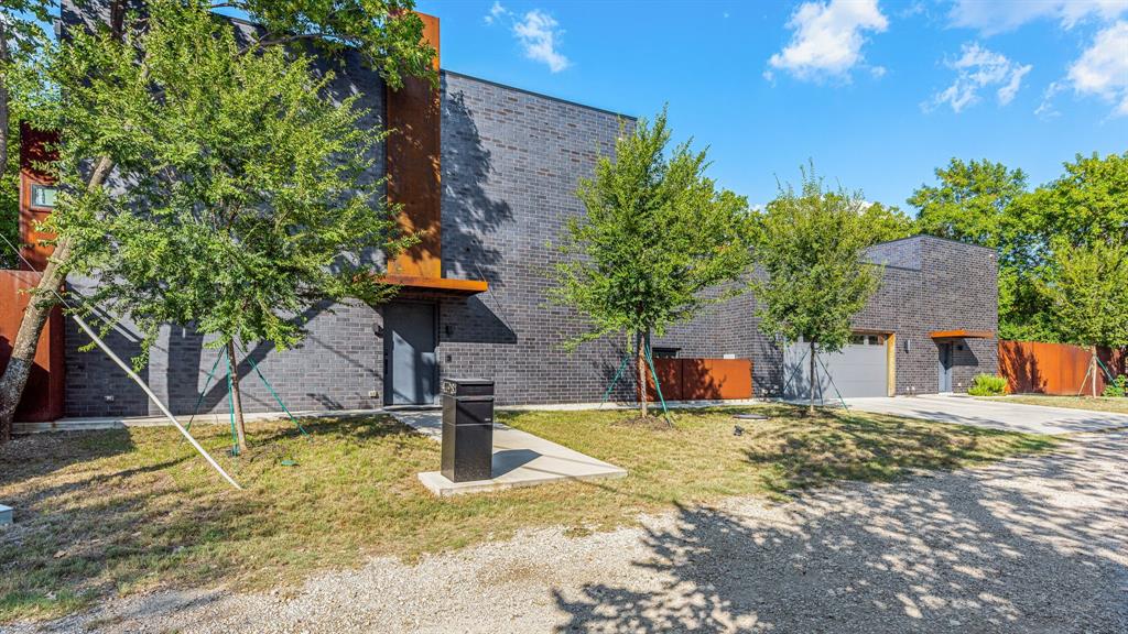 This modern take on a European walled compound knocks it out of the ballpark. Completed in 2021, the home was inspired by vacations in Spain but realized as a modern design featuring commercial quality materials, including an oversized Acme Iron-spot brick and artisan steelwork. Located on .445 acres, the “compound” features 3 separate living spaces, the 3 bedroom, 3.5 bath main house + the attached 2 story apartment + the 1260 sq ft detached 2 bedroom, 2 bath guest house. County measurements total everything, including the attached garage, as 5486 sq ft. Each structure is foam insulated. Situated on a cul-de-sac, beyond its gated driveway and fortress-like facade, one is connected immediately to nature. The NE boundary is the wooded Old Trinity River Channel. Designed for multigenerational living, the property is very well suited for creatives who want a live work homebase in separate but connected facilities. There are open living areas with polished concrete floors and tall ceiling rooms flooded with natural light.  A covered porch is the perfect place to take in the home’s central “green” and there is a roof top terrace. Appliances include a Dacor 36” stainless-steel refrigerator, freezer, and 24” wine fridge. There are Blue Star double ovens with and a Blue Star 8-burner gas range. Stainless-steel countertops with integrated sinks will please the most discerning chefs! On the 2nd floor of the main home are 3 bedrooms & 3 baths, each with decorator tile. The primary suite has a walk-in double shower with a view of the skyline. The 2-story loft apartment has its own entrance. Detached is a luxurious 2 bedroom guest house with an open living area, full kitchen, 2 custom baths, and a covered porch. MU-1 Zoning allows for multiple uses. Surrounded by live-work residences, galleries and showrooms, the lot size and nature preserve setting make this home a one-of-a-kind.