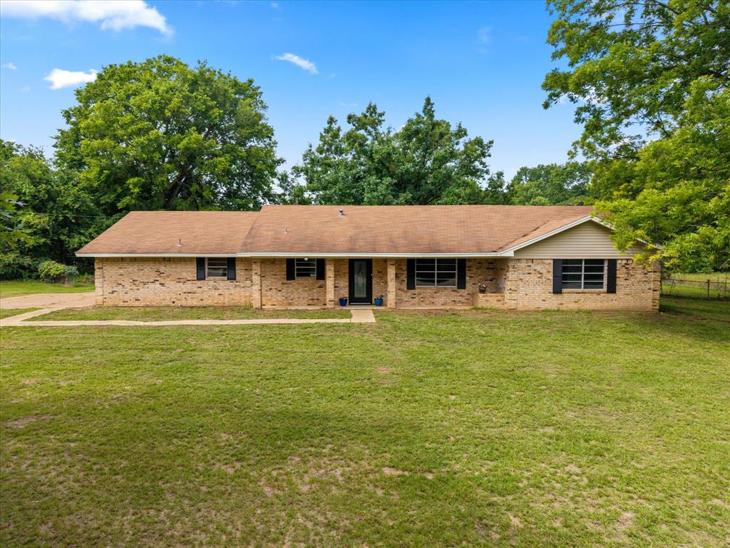 Escape to peaceful country living on 1.8 beautiful acres just minutes from Lake Quitman and close to world famous Lake Fork! This recently remodeled 3 bedroom, 2 bath home offers 1,866 square feet of light filled living space with updates throughout, including all new flooring, fresh paint, modern light fixtures, and new appliances. The spacious kitchen is designed for both everyday living and entertaining, featuring granite countertops, abundant cabinetry, and a bright open feel. The inviting living area centers around a cozy wood burning fireplace, creating the perfect gathering space. The private primary suite offers a relaxing retreat with an ensuite bath and separate his and her closets. Large windows throughout the home bring in natural light and showcase the peaceful surroundings. Step outside and enjoy the screened in porch overlooking the property, complete with a huge mature pecan tree that adds shade and charm. A 25x29 shop provides excellent space for hobbies, storage, or projects, while the attached 2 car garage adds convenience. Located in sought after Quitman ISD, this property combines updated comfort with the tranquility of country living. Whether you’re looking for a full time residence or a weekend retreat near the lakes, this one truly offers country living at its best!