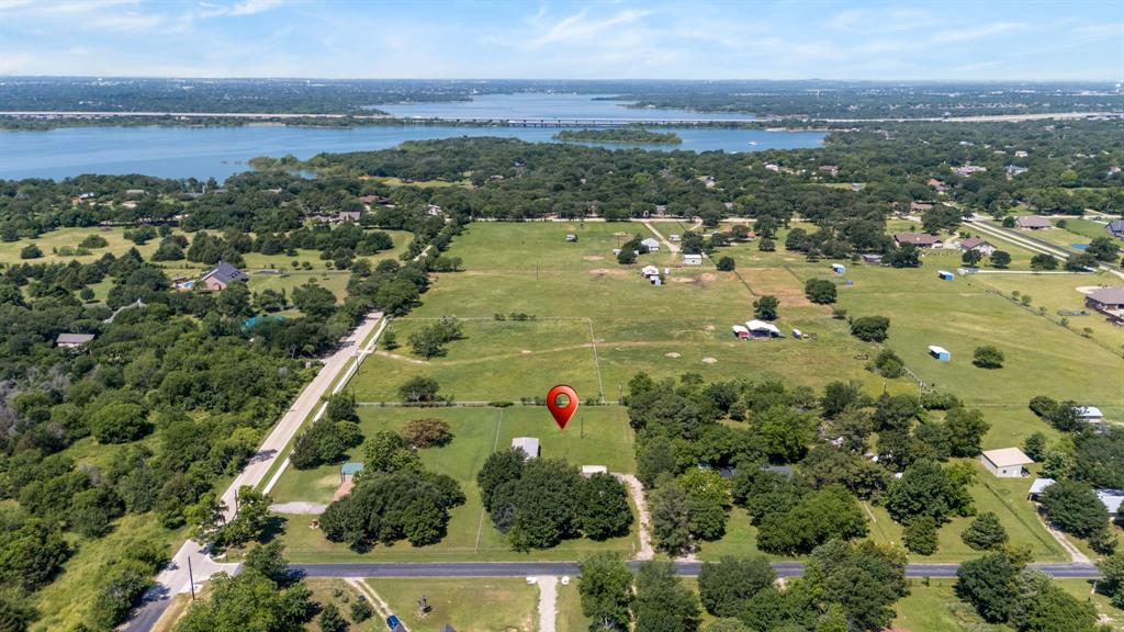 Rare opportunity to own a full acre on Wolters Street in Lake Dallas just moments from the shoreline of Lewisville Lake. With an existing home already on the property, this parcel offers the perfect opportunity for someone ready to build their dream home in one of the area’s most desirable lake-adjacent locations. Positioned on one of the closest residential streets to both Westlake Park and Oakland Park, you will enjoy quick access to boat ramps, camping, fishing, hiking trails, and everything lake life has to offer. The size of the lot provides room to create a true custom retreat with space for additional garages, workshops, outdoor entertaining areas, or simply extra privacy that is hard to find this close to the water. Whether you are looking to renovate, rebuild, or create a completely custom estate near the lake, this property combines location, acreage, and potential in a way that rarely becomes available. Convenient access to I-35E keeps you connected to Denton, Dallas, and the surrounding Metroplex while still enjoying the relaxed atmosphere of lakeside living.