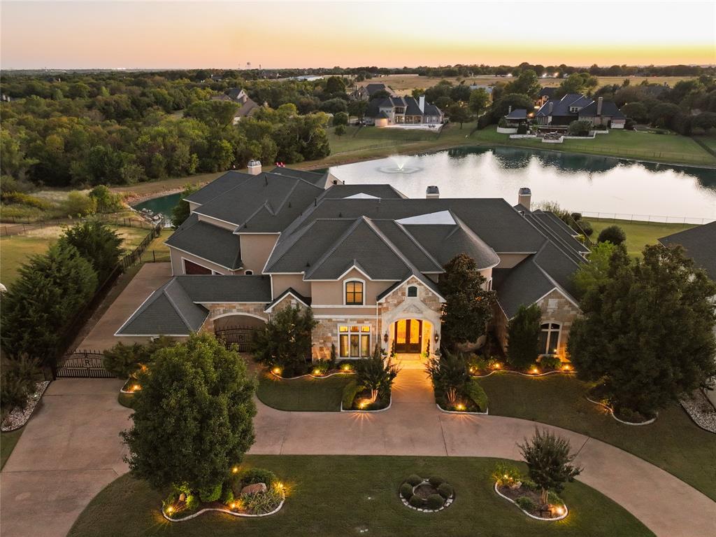 Executive Mediterranean Estate on Nearly an Acre, with lake views! This stately home is perfect for large gatherings, entertaining, fundraising, and enjoying life. 

This exceptional Mediterranean-style estate offers 9925 square feet of luxury living on meticulously maintained landscaped lawn with tranquil lake views. Designed for both grand entertaining and comfortable everyday living, this custom-built home showcase rich millwork, Jerusalem tile flooring, hand-carved Austin stone in formal living and around stove.

A grand foyer with a sweeping staircase sets an impressive tone upon entry. Multiple spacious living areas flow seamlessly throughout, including a main family room with a full bar, massive fireplace with stunning millwork,  views of the resort-style backyard and adjacent to a separate dining area and secondary seating area. The gourmet kitchen features high-end appliances, extensive cabinetry, and a layout ideal for hosting or family gatherings. There are 2 large islands, one with bar-height seating and large breakfast area with poolside and lake views.  Multiple closets and storage rooms are a convenience with many visitors. 

There are two dedicated offices, a magnificent theatre room, abundant built-ins, balancing luxury with everyday function.
 The primary suite offers a serene retreat with a spa-inspired bath, oversized custom closet, and private access to outdoor living areas, and flex room used as a gym

Step outside to a multi-tiered backyard paradise featuring a sparkling pool, relaxing spa, covered patios, full bath, and multiple sitting areas overlooking the peaceful lake—perfect for entertaining or unwinding at sunset.

Additional highlights include 4 spacious bedrooms, 4-car garage, doggy bath area, 2 tankless water heaters, extensive storage,  refined finishes throughout. Every corner of this home reflects craftsmanship, comfort, and style, offering the ultimate Heath lifestyle in one of the area’s most sought-after communities.