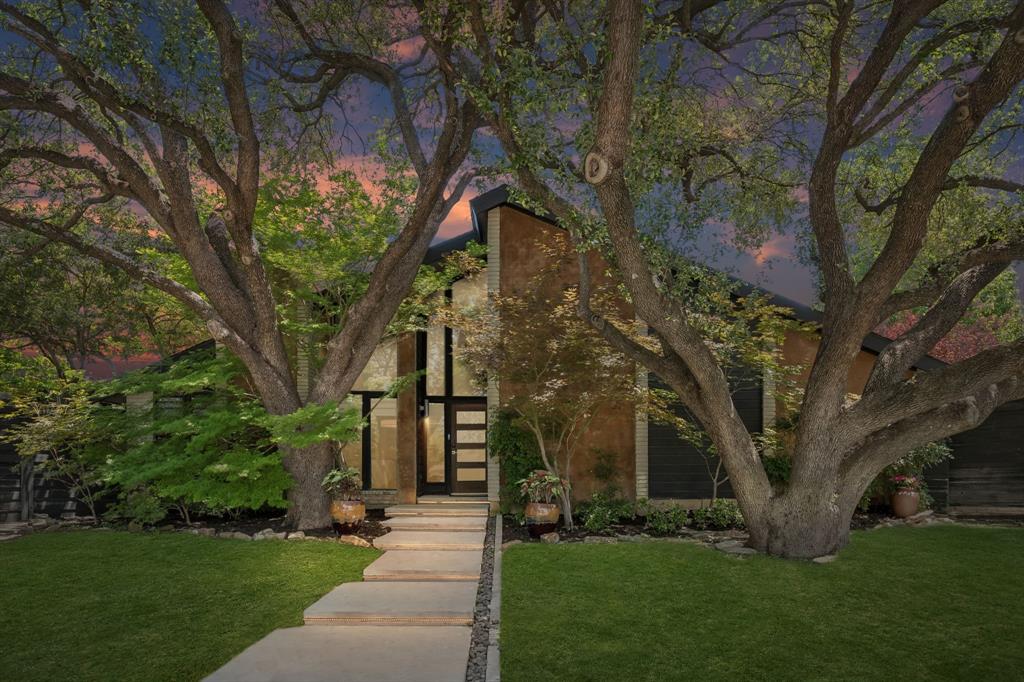 15 miles north of downtown Dallas, find this stunning soft contemporary with a dramatic entry, nestled under a canopy of mature trees! Zoned to coveted Brentfield Elementary, part of Richardson ISD. Built in 1978 on a .33 acre lot, you'll find an expansive yard space, pool, workshop, & amazing outdoor patio. Laid out perfectly on one level, the home has two large living rooms with towering ceilings on either side of the home, centered by a chef's kitchen. Warm wood accents give authentic character along with unique lighting in many facets of the home. Sizable kitchen features Bosch appliances, including a 5-burner gas range. A long sunroom splits the kitchen and patio, creating wonderful views outward towards the pool scene. A true entertainer's dream awaits on the covered patio, with an outdoor fireplace, gas grill, mini fridge, & large sitting area. Pool built circa 2013 has a hot tub & waterfall feature. All this alongside a sizable yard, encompassed by a wooden privacy fence & Viking sliding gate. The 2-level garage has a Versa Lift & full workshop. Be worry-free in the event of a power outage, as you'll find comfort in the whole-house Kohler Generator! Loaded with extras, this home will not disappoint. 22 mins to DFW Airport & located near several major thoroughfares. Just .5 mile south is a hot new development, Hillcrest Village Green. Don't miss out!
