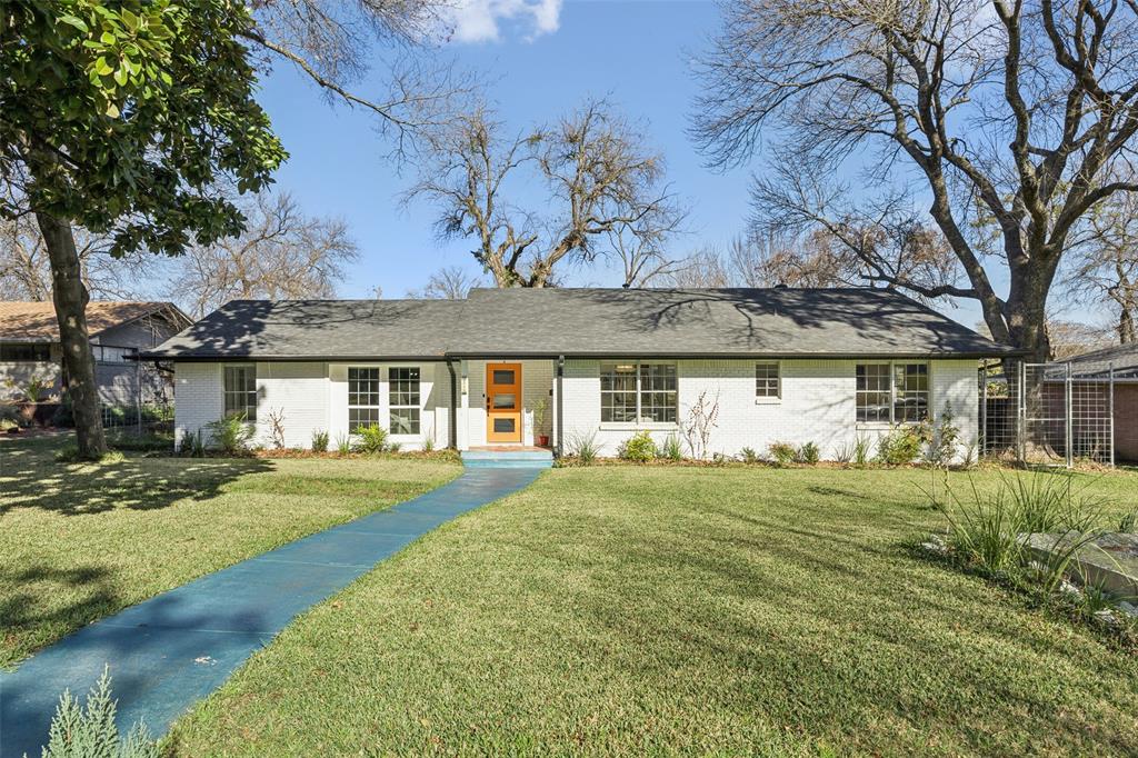 Thoughtfully and completely updated, this contemporary ranch blends wide-open living spaces with beautiful natural light and a clean, modern aesthetic. Soft, neutral tones and smooth gallery walls create a timeless backdrop, while contemporary lighting adds subtle sophistication throughout. The open-concept living area is anchored by a striking fireplace framed by walls of windows, creating a seamless connection between indoor comfort and outdoor views. Set on a wide, welcoming lot, the home is surrounded by mature trees, a tranquil fountain, and a freshly manicured lawn that immediately sets the tone. Inside, a glass-enclosed patio offers exceptional versatility—perfect as a studio, home office, or creative retreat—overlooking the redesigned backyard. The outdoor space is truly an extension of the home, featuring a custom patio with a built-in fire pit and outdoor kitchen, both plumbed for gas, making it ideal for entertaining year-round. A large utility room with abundant storage adds rare functionality for a home of this era. Recent upgrades include the enclosed studio, sprinkler system, HVAC, tankless water heater, new PVC plumbing, electric gate with metal fencing, French drains, and gutters. Fun, inviting, and beautifully improved, this is a home that lives as well as it looks.