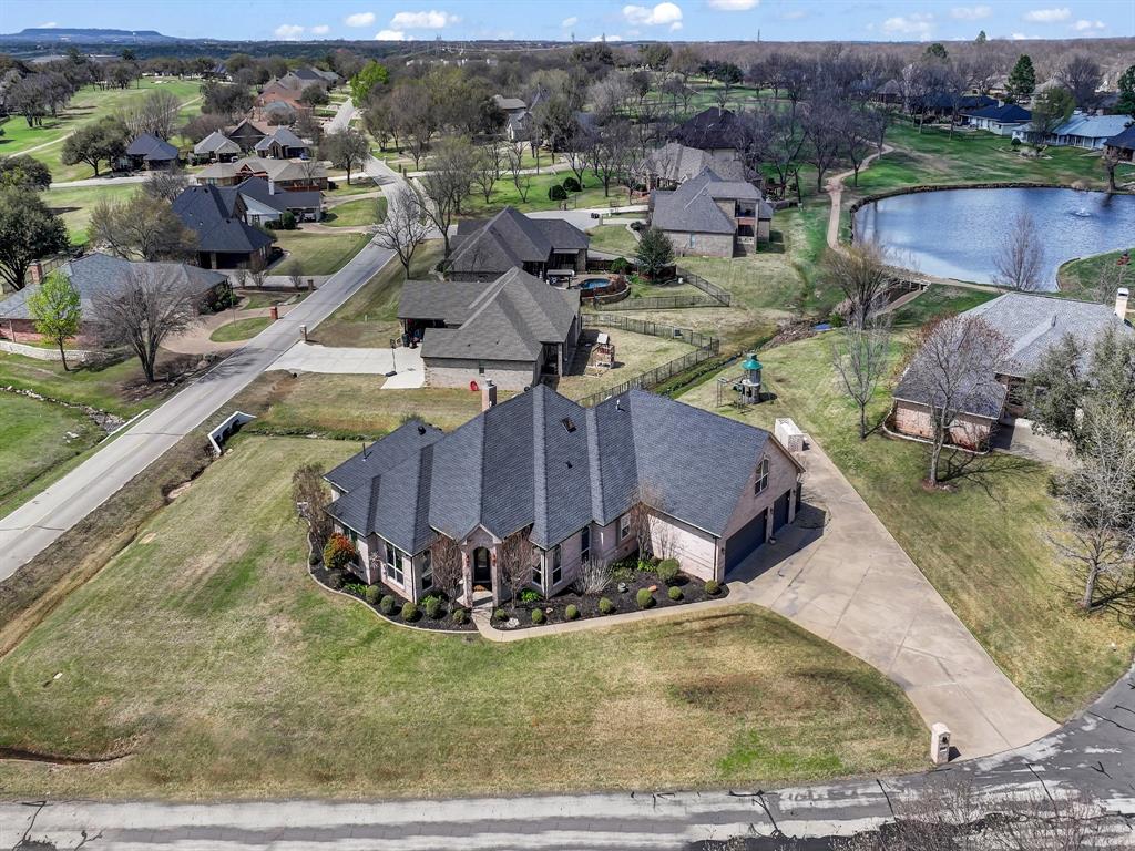 Impressive curb appeal welcomes you from the moment you arrive at this corner-lot home, nestled in the heart of the gated & guarded sought after neighborhood, Pecan Plantation. This spacious home blends modern upgrades with timeless charm, offering both style and long-term functionality. 
Inside, the open-concept layout is filled with natural light and features a front office with ample windows. The main living area is anchored by a massive brick fireplace with hearth and built-ins, creating a warm and inviting focal point. Tile installed in 2021 adds both beauty and durability.
The chef-inspired kitchen is designed for everyday living and entertaining, offering abundant cabinetry, generous counter space, and a convenient breakfast bar. The oversized laundry room includes a sink and extensive cabinet storage for added functionality.
The first-floor primary suite features an oversized en-suite bath with dual vanities, walk-in shower, freestanding tub, and a large walk-in closet. This home features spacious bonus rooms, one with built-in bar space, ideal for entertaining, media, or flexible living.
Step outside to an impressive oversized outdoor living space, built-in rock fireplace, built-in grill, and ample exterior countertop space, perfect for hosting or relaxing year-round with golf course views!

The 3-car garage plus additional golf cart garage provides exceptional storage and convenience, ideal for easily pulling out your golf cart to cruise the neighborhood or storing lawn equipment.

Major improvements include AC units (2023) and attic roofline spray-foam (2023) delivering enhanced energy efficiency and year-round comfort.

Residents of Pecan Plantation enjoy unmatched amenities!

A rare opportunity to own a beautifully upgraded home with space, comfort, and lifestyle at the forefront. Drainage ditch along Bellechase is being addressed and corrected by PPOA.