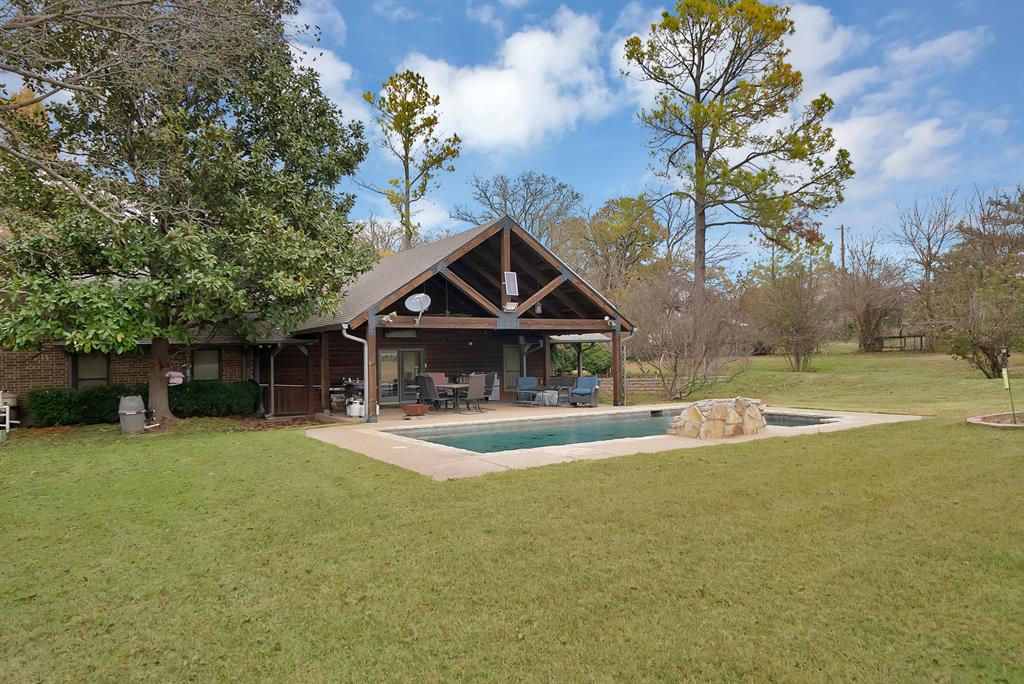 Welcome to this multigenerational property that is perfectly designed for comfort, function, and opportunity. Nestled behind a beautifully tree-lined driveway sitting back off a country road, this spacious home features expansive front and back porches that are ideal for relaxing or entertaining alongside the stunning pool. It also offers nature lovers many opportunities with all the wildlife, wild fruit bushes and trees, a tank and tons of land for livestock or gardening. There is plenty of room for an arena to be built. The main house offers 4 bedrooms with 3.5 bathrooms, 2 living and 2 dining areas. The custom barndominium ,being the second home on the property, offers an open concept living and kitchen with 3 bedrooms and a large bathroom with a utility room.   There is a large barn, 5 stalls, corral, and a vast pasture with a tank and well out in the pasture. With three water wells, agricultural tax exemption, and no known restrictions, this property offers true flexibility for a variety of uses. Bring all the animals and enjoy your own ranchette or make it into an income producing investment property. Additional features include a chicken coop, an indoor and outdoor dog kennel, a dedicated dog grooming space, and a large workshop. Whether you’re seeking a peaceful country lifestyle, a multigenerational retreat, a place to call home with multiple shops and plenty of room to add on or an investment property, the possibilities here are truly endless. So many possibilities with all the land and terrain. Game feeders, hunting blind, chutes gates, 3 safes, all tv's, washer and dryer, refrigerator, and front porch swing all convey. With all this and more to offer come and make this your dream home! Come out to see what all this property has to offer.
