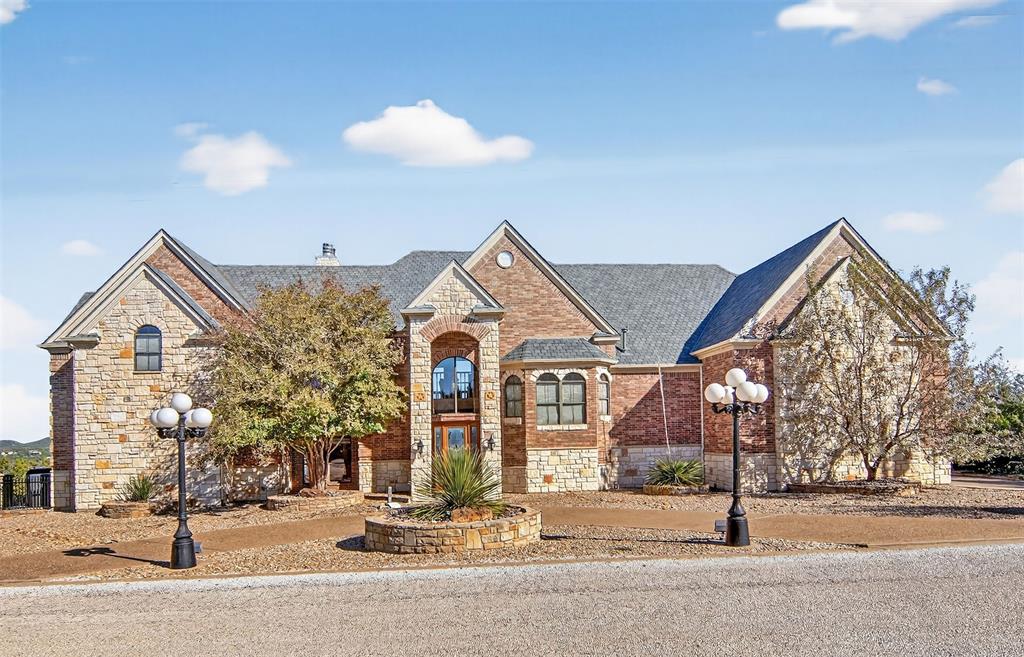 Nestled within the esteemed Cliffs Resort community, this custom-built masterpiece, sitting on 2 lots, offers an unparalleled living experience. Sophisticated design blends grandeur with intimate comfortable living spaces. Privacy, distinction a front row access to the best of Possum Kingdom Lake Life. 180-degree panoramic views of the main channel provide a front row seat to all the action. The private primary suite is a serene retreat boasting a fire place and a spacious walk-in closet. Entertainment options include a large gourmet Kitchen, a full-size media room with tiered seating, great room, custom 15x24 in-ground pool featuring one of the best lake views on PK. For convenience, ride in style to the second level in the 500lb capacity elevator. The oversize garage with extra storage provides room for lake toys and a golf cart. An equipped exercise room can be enjoyed by all. An office with a built in desk is located on the second level. A Chaparral Sonesta Boat, Trailer, 30 foot slip with a power lift and a golf cart are negotiable along with other items in the home. Ownership in the Cliffs Resort provides access to the Marina, Restaurant, Hotel, Fitness Center, 2 Pools, Tennis Courts, Play Ground, Golf Course , 36 rounds of golf per year.