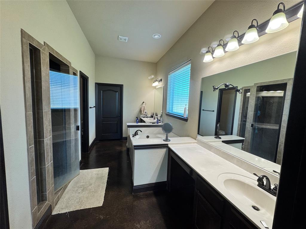Discover refined living in this custom-built luxury estate on a premium 1+ acre lot in the exclusive Preserve Oaks community. Designed with craftsmanship, privacy, and sophistication in mind, this four-bedroom, three-bath residence blends timeless architectural detail with modern high-end upgrades.

Step inside to 11-foot ceilings, an expansive great room, and surround-sound theater system that elevate everyday living. Custom built-ins, stained concrete flooring, and a wood-burning fireplace create a warm, upscale ambiance ideal for both intimate evenings and entertaining.

The chef-inspired kitchen features slab granite countertops, premium appliances, an oversized walk-in pantry, and generous workspace perfect for hosting family dinners and large gatherings.

A private office with a separate exterior entrance offers convenience, discretion, and work–life balance.

Recent upgrades exceeding $100,000 include:
 • Brand-new roof
 • Energy-efficient commercial windows
 • Professional exterior repaint
 • New commercial gutter system

The three-car garage includes an oversized bay with 9+ ft clearance for trucks or recreational equipment.

Outdoors, a $30,000+ wrought-iron fence with automatic security gate ensures elegance and peace of mind. With over an acre, design the ultimate outdoor retreat—pool, workshop, or casita.

This estate blends luxury, security, and function—a private Texas home where craftsmanship meets comfort. Move-in ready and impeccably maintained, it invites you to a lifestyle of ease, quality, and prestige.