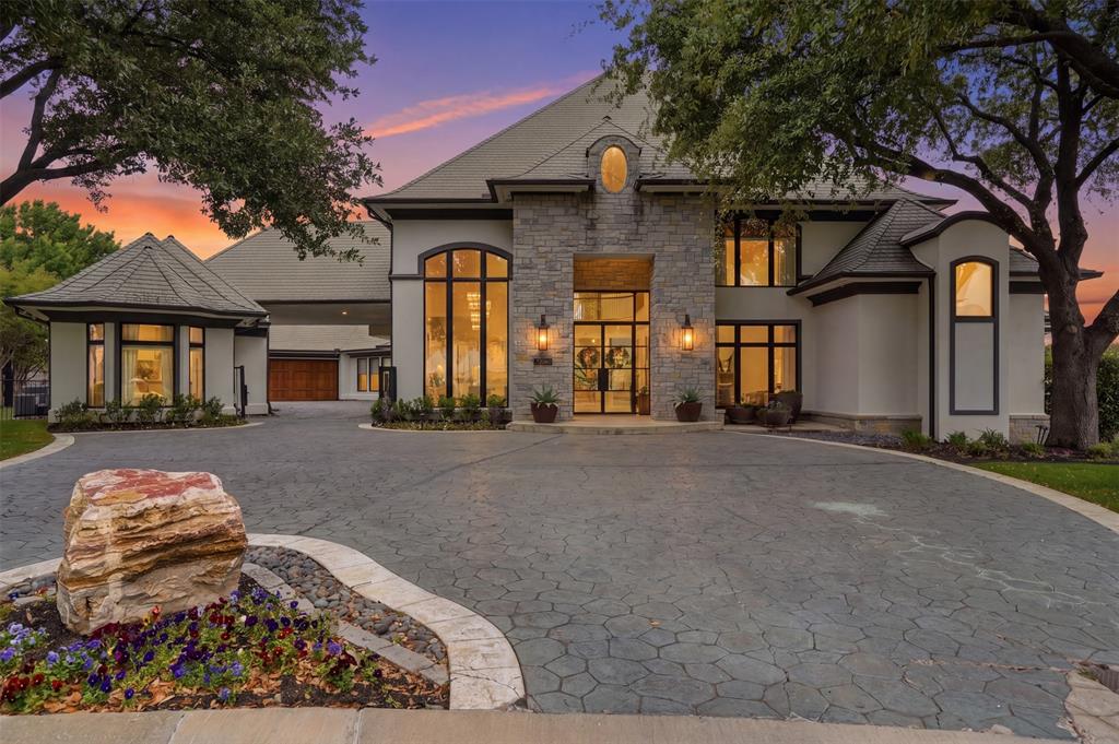 Refined, architectural elegance meets effortless luxury in this stunning estate, perfectly positioned on the 7th hole of Mira Vista Country Club with lake views. Every detail has been thoughtfully curated for both grand entertaining and everyday living. Set at the end of a cul-de-sac and framed by mature trees, the striking stone-and-stucco façade makes an unforgettable first impression.

Inside, soaring ceilings and expansive walls of glass flood the home with natural light, seamlessly connecting indoor and outdoor living. The main living area showcases a dramatic fireplace, wide-plank hardwood floors, and panoramic views of the resort-style backyard and golf course. A designer kitchen anchors the home with an oversized marble island, professional-grade appliances, custom cabinetry, and an open flow into multiple gathering spaces.

The primary suite is a true retreat, featuring a striking see-through fireplace shared with the spa-inspired bathroom, creating a serene, resort-like ambiance. The bath is wrapped in luxurious marble and includes a freestanding soaking tub and dual walk-in showers. All six generously sized bedrooms feature private en suite baths, offering comfort and privacy for family and guests alike. Additional living spaces include a sophisticated dining room with statement lighting and custom wall treatments and a private office with custom built-ins offer many flexible areas for work or leisure.

Separate guest quarters offer exceptional flexibility, complete with a full kitchen and full bathroom—ideal for extended stays, guests, or private flex space.

Step outside to your private oasis—an expansive patio, sparkling pool, gas fire pit, and manicured grounds overlooking serene green space create the ultimate setting for relaxation or entertaining under the stars.

With its seamless blend of modern sophistication and timeless design, this exceptional property offers elevated living at every turn.