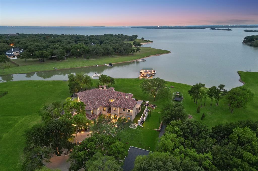 Mediterranean lake house on 2+acres with a rare personal permitted dock on Lake Lewisville! Dock features every convenience incl lift, multiple slips, electric, gas & wifi! Turfed backyard with multiple sound zones, sitting areas, dog run, play areas, gas fire pits & extensive mosquito misters & lighting system. Incredible patio with heat & ac boasts a well-appointed & spacious wet bar with custom backlit alabaster feature wall, multiple entertaining areas, dehumidifier & more! Dreamy kitchen features quartz, custom tile b-splash, Wolf apps, Miele coffee maker, abundant cabinetry w glass uppers, apron front sink, sub-zero fridge &  island w veg sink. Family room ideal for entertaining with a wall of sliders to the patio! Formal dining with sitting area. Impressive study has lighted built-ins with library ladder. Master bedroom w fireplace & luxe master bath down. 4 additional bdrms up including a suite with kitchenette, washer, dryer  & balcony; plus game rm w loft & a craft room!