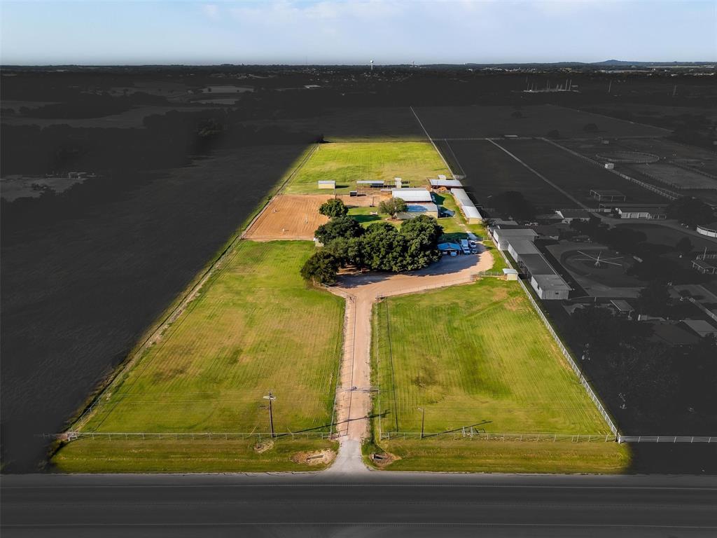 10 Acres Right Here in the Heart of Burleson, This 10 acre fully pipe fenced Turn Key Farm and Ranch property has lots to offer. Starting with the long driveway that separates two large turnout pastures with covered loafing sheds, to follow is the sprawling Ranch Style Home that accommodates, 3bedrooms 2full bath, 2family rooms a kitchen, that is the heart of the home, a dinning area, and so much more to offer. Every room feels very spacious. From the back of the home you overlook the 40 by 60 show barn that contains, concrete flooring 4 stalls a feed room, tack room and storage room,  2 wash racks located at the front of the barn and the back. A large 5,000 pound working grain bin attached. Another 40 by 60 barn that includes 3 stalls, a concrete walk way. This  barn also holds a concreted area with a horse stock, sink , hot water heater, along with a 12 by 24 office that contains a restroom and shower.  The third barn is a 20 by 30 fully inclosed hay barn. More stalls along the side of the property as well.     Holding a total of 30 horse stalls and 10 outdoor pens that each have a loafing shed for cover. This Ranch also holds a 55ft covered round pen, 6 horse walker, 250 by 125 piped riding arena. If you think it didn't already have everything well it does, it also has a large 5 acre pasture that can be used to produce hay or for turnout.  This Ranch has hosted many Burleson FFA and 4H judging practice shows, given lots of riding lessons, boarded horses and used as an equine breeding facility. The Income or Investment  potential is Unlimited Here, being minutes from Burleson with all the amenities, but yet still outside of the city limits.  You can use this Property for Income or just be kept to yourself to enjoy the peacefulness it has to offer.   Schedule that showing today!! Serious enquires only please.