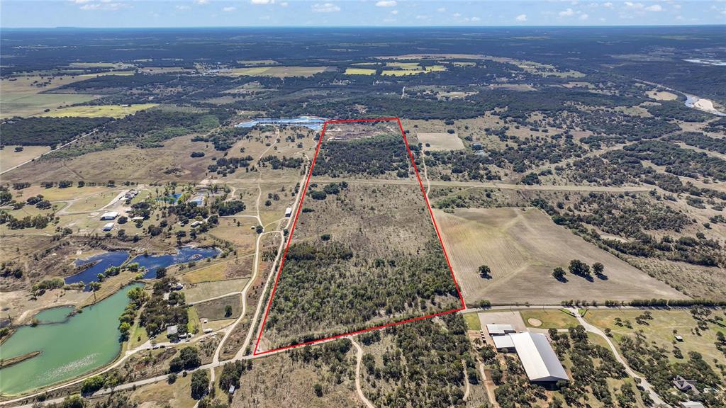Multiple excellent homesite locations on 93 acres with 913 feet of road frontage on Grindstone Rd, many hardwood trees on the property and some mesquite, cleared areas and varied topography, minutes away from Brock schools.  Property can be bought as one platted parcel now however owner is in the process of subdividing and price will increase once subdivided. A 16-foot-wide gravel road, graded and compacted, with over 12 inches of base, borders approximately two thirds of the eastern side of property, then cuts through the middle and continues to the back portion of the property.   Back 28.36 acres of the property was previously used as a rock quarry, creating three stock ponds at back of property and has the potential to be converted into a recreational area. All information in this listing is deemed reliable; however, buyers and their agents are advised to verify all details independently.
