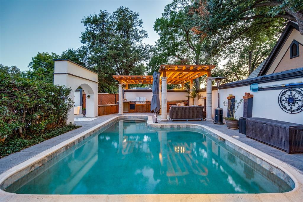 One-of-a-kind luxury home in the heart of Oak Lawn, beautifully updated from top to bottom with modern finishes & resort-style outdoor living. Surrounded by a fully fenced stucco privacy wall & enhanced with low-maintenance landscaping. Step through the front gate & feel instantly transported to your own paradise. The outdoor oasis features a saltwater pool with an oversized heater, a cedar pergola covering a fully equipped outdoor kitchen with a built-in Dacor BBQ grill, sink, & fridge, & a large round gas fire pit perfect for entertaining. A stamped concrete walkway guides you to the front entrance, where a unique water feature creates an unforgettable first impression. Inside, new oak hardwood flooring flows throughout the home. The spacious living room is lined with floor-to-ceiling windows that showcase views of the pool & outdoor living spaces. The completely remodeled chef’s kitchen is a showstopper, featuring custom real wood cabinetry, porcelain countertops, an oversized waterfall island, built-in fridge, 48-inch Dacor dual-fuel range with double ovens, large breakfast bar, & walk-in pantry. The elegant dining room offers designer lighting & a stylish dry bar complete with dual built-in wine fridges. The luxurious primary suite features tray ceiling details, custom lighting, & two custom walk-in closets. The spa-inspired primary bath includes heated floors, dual sinks with marble countertops, an oversized soaking tub with TV, & a marble walk-in shower & three-zone spray system. Upstairs, you’ll find two spacious secondary bedrooms connected by a beautifully updated Jack-and-Jill bathroom featuring porcelain tile, porcelain countertops, and premium finishes. Both bedrooms offer multiple walk-in closets & private access to the expansive balcony, which features cedar construction, black wrought iron accents, & LED lighting. Additional updates include two new HVAC systems installed in 2026, providing comfort and efficiency for years to come.