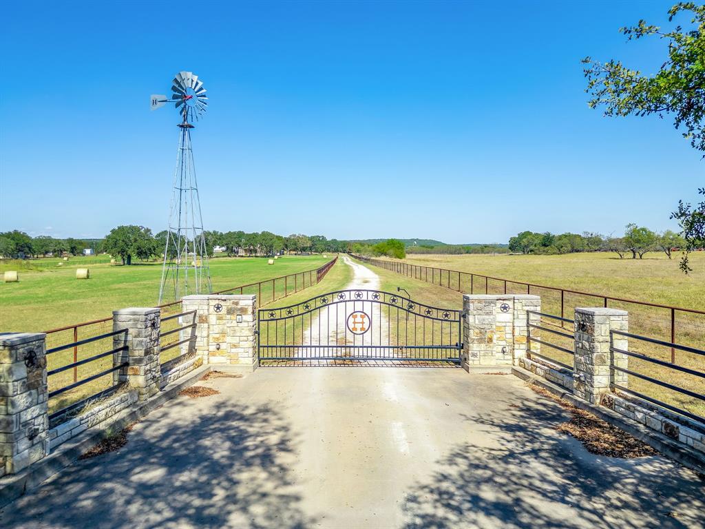 Built like a fortress, this extraordinary custom home sits on nearly 16 acres of sandy soil in the heart of North Texas horse country, just minutes from Weatherford, the Cutting Horse Capital of the World.  40+ GPM WATER WELL - Hard to find in North Texas!

The stunning great room features 25+ foot cathedral ceilings, exposed beams, and a massive floor-to-ceiling stone fireplace, creating a dramatic gathering space overlooking the coastal pasture.

The chef’s kitchen is built for entertaining, centered around a massive island and featuring a KitchenAid 8-burner gas range with double ovens, plus a wine fridge and built-in ice maker, surrounded by custom hickory cabinetry and ample counter space.

The home offers 5 bedrooms (including an office that can serve as a bedroom), 3.5 baths, a gym, formal dining room and more.

Built with exceptional durability, the home includes 2x6 framing on 16-inch centers, spray foam insulation, and a foundation supported by 30 piers drilled into bedrock. Additional highlights include 18-inch beams, 1-inch plywood flooring upstairs, and a Western Red Cedar and Austin Stone exterior.

Recent improvements include fresh interior paint, updated bathrooms, refinished stairs, new kitchen countertops, epoxy garage floors, and landscaping upgrades. Major updates include a new roof in 2024 and brand new main HVAC unit in 2026, plus two tankless water heaters, three HVAC systems, and a Generac backup generator.

Enjoy outdoor living with a new heated pool and spa. The property is fully fenced and cross-fenced with pipe fencing and features 15.948 acres of coastal bermuda pasture, three barns or shops with water and electricity, four horse stalls, a stock tank, and windmill structure with additional water well (condition unknown).
Properties of this quality are rare in North Texas. Schedule your private tour and experience this exceptional ranch estate. All info is deemed reliable but not guaranteed and should be verfied by buyer.