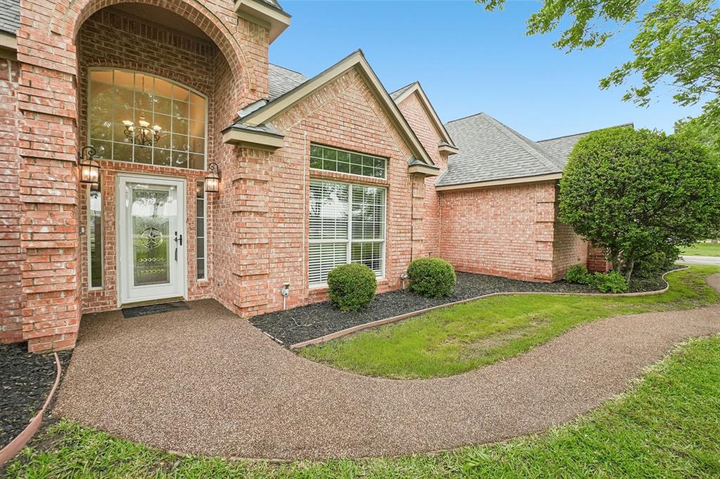 1 acre in Ennis, TX featuring a 5 bedroom, 3.5 bath home with 3,226 sq ft built in 2000, a 24x40 insulated workshop with electricity, 2 car carport, and 3 car garage. Recently upgraded concrete driveway provides additional parking space and convenience. The backyard offers a resort style pool with waterfall and water slide, along with recently added rubber cap surfacing for durability and comfort around the pool and patio, all surrounded by mature pecan trees. Fully paid off solar panels provide long term energy savings. This beautifully maintained home offers a functional open floor plan designed for everyday living and entertaining. A welcoming entry with upgraded rubber cap flooring creates a clean, durable, and modern first impression. As you enter, you find a dedicated office space, an open living room with a brick fireplace, abundant natural light, and large windows overlooking the backyard. The kitchen includes granite countertops and ample cabinetry, with a dining area that flows seamlessly for gatherings. The laundry room includes a sink and storage cabinets. The first floor features a split primary suite for added privacy. One secondary bedroom connects directly to the primary closet, offering flexibility for a nursery, gym, or flex space. A full bathroom serves the secondary bedrooms, along with a half bath with convenient outdoor access to the pool. Upstairs includes a media room with balcony access, an additional bedroom or game room, and a full bathroom, creating a private second level retreat. Major updates include recently completed foundation repair with transferable documentation, two water heaters replaced within the last two years, HVAC system serviced twice yearly across three AC units, and septic system serviced every four months with the seller covering an additional year, and freshly repainted. Located in a quiet neighborhood with a dead end feel and easy access to Highway 287. Everything a Texas home has to offer on a full acre in Ennis.