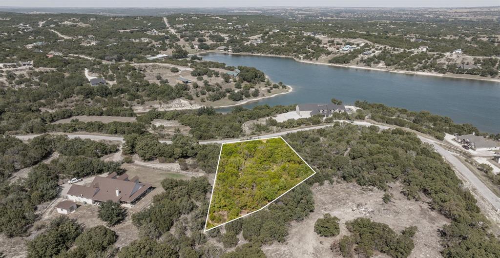 One-acre lot with a FABULOUS view of Beacon Lake! Enjoy miles and miles of stunning scenery from one of the best vantage points in Mountain Lakes. This property offers an excellent building site and an easy walk through beautiful hardwoods. Conveniently located in the heart of the subdivision, with water and electricity available at the front of the lot. No build time requirement and a 1,400 sq. ft. minimum living space. Annual assessment is just 295. Located in Bluff Dale, Texas—perfectly situated on Hwy 377 between the Cowboy Capital of the World, Stephenville, and the historic town of Granbury. Come experience breathtaking Texas sunsets, star-filled skies, and abundant wildlife. Mountain Lakes amenities include a recreational lake, fishing lake, clubhouse, pool, park, walking path, garden, and RV park—country living at its finest!