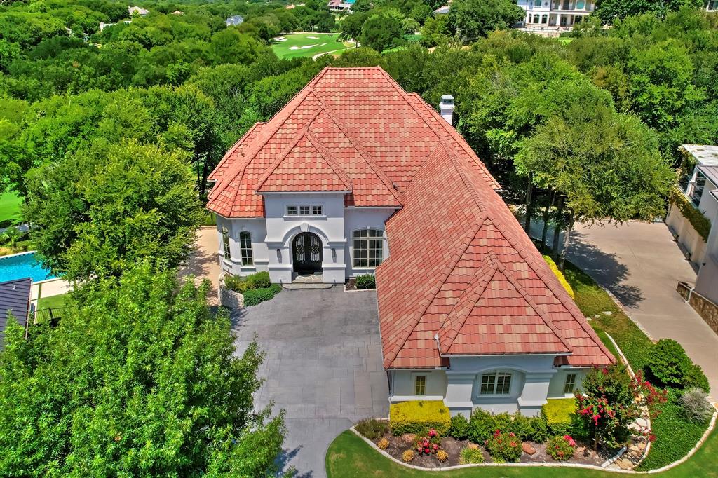This beautifully remodeled modern estate, originally designed by Sean Knight and transformed by Providence Homes in 2020, is located within the exclusive, gated, and guarded golf course community of Mira Vista. The home is perfectly positioned overlooking the 13th fairway, offering breathtaking views from every angle. Expansive windows throughout the home showcase the stunning pool and outdoor living spaces, creating an incredible atmosphere for relaxation and entertaining. The gourmet kitchen is a chef's dream, featuring quartz countertops, professional-grade appliances, a steam oven, built-in coffee maker, dual sinks, and a large island with seating for six. The primary suite is a true retreat, featuring a spa-inspired ensuite with a freestanding jetted tub, separate shower, dual vanities, and a custom closet. Continuing on the main floor, you'll find a guest bedroom with an ensuite. The lower level features two additional guest bedrooms, each with an ensuite, along with a game room, media room, exercise room, and an extra living area complete with a wet bar. Large glass retractable doors open up to an exceptional indoor-outdoor entertaining space. An elevator provides easy access to both livable floors and the attic. The oversized three-car garage is equipped with vinyl flooring, built-in cabinets, and a built-in refrigerator. The backyard offers a spacious pool, retractable awning, and multiple balconies and porches that provide stunning views from every angle of the property.