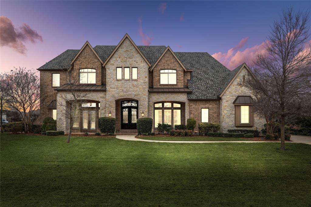 This stunning custom estate exemplifies luxury and sophistication, set on 1.2 premium acres with breathtaking waterfront views! Elevated architectural design, detailed ceilings, hardwood floors, and solid doors exude timeless elegance and quality craftmanship. Grand entrance with imperial staircase and immediate views of the lake beyond. Private executive office with custom cabinetry. Natural light fills the family room with a cathedral ceiling displaying beautiful wood beams, built-in cabinetry flanking the two-story fireplace and floor to ceiling windows overlooking your outdoor oasis. Enjoy a lakefront sunrise from the spacious breakfast room and gourmet kitchen. A chef’s dream, featuring a large center island with seating, soaring cabinetry, commercial-grade appliances, 6-burner Wolf range plus griddle, pot filler, double oven, and built-in ice maker. The adjacent dining room is perfect for large formal gatherings and connects seamlessly to the butler's pantry and bar equipped with a warming drawer, beverage fridge, and sink. Convenient walk-through pantry with third sink, second refrigerator, and dishwasher. The primary suite is a sanctuary tucked away with pool access and two-sided fireplace adjoining to your spa bath with double vanities, walk-in shower, relaxing soaking tub, and custom closet. Main level second primary suite offers lake views, spa bath, and pool access. Sprawling second level includes four additional bedrooms with private baths, a second office, craft room, massive walk-in storage, and game room with a pass-through bar and beverage fridge connecting to your media room for easy hosting. Designed to entertain on a grand scale, your backyard retreat features a two-sided fireplace serving both your covered living area and pool with spa on other side with additional fire features.  Outdoor kitchen, bar with seating, and multiple lounging areas with serene lake views. This exquisite property offers a lifestyle of elegance and comfort. Perfection!
