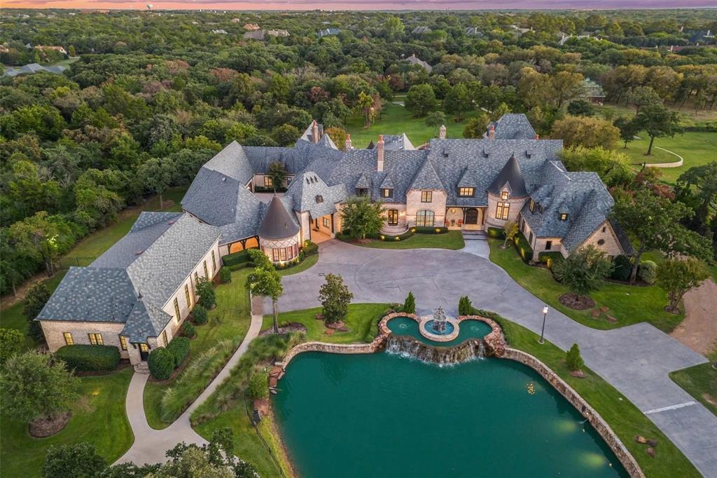 Introducing one of the most majestic gated estate properties in Southlake! 935 W. Dove Road exudes opulence on over 7 acres featuring a private pond with gorgeous fountains. A true dream estate with over 20,708 square feet featuring venetian plaster, marble, onyx, hardwoods, slate roofing & copper gutters. Designed for grande-scale entertaining and family living, this estate has it all: a bowling alley, game room with bar, tiered media room, indoor sports court, exercise room, 10-car garage, and more! A stunning kitchen with designer finishes opens to a luxurious living area. Extraordinary Owner’s Quarters complete with living area, grand bedroom with abundant custom closets, and spa-like en-suite opening to private outdoor spa. Park-like acreage boasts lush landscaping and paved walking paths surrounded by native oak trees. Entertain with the resort-style pool with multiple water features, a relaxing spa, and a covered patio with an outdoor kitchen. Come see and experience excellence!