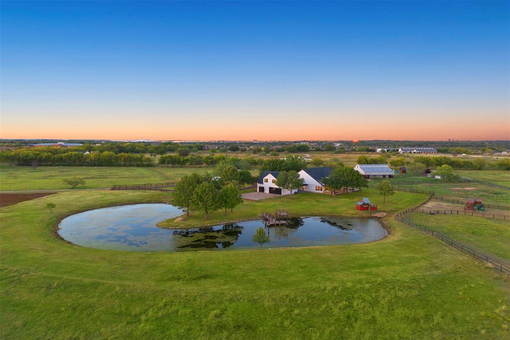 AG EXEMPT & NO City taxes. Construction is now complete on this remarkable estate, set on 11.7 acres of private, scenic land in the heart of Argyle. Completely taken down to the studs and rebuilt with high-end designer selections, this home blends transitional style with timeless craftsmanship and refined living. Inside, soaring ceilings and a floor-to-ceiling fireplace set the tone in the living room, framed by custom cabinetry and a wall of windows that capture breathtaking views of the property. The adjoining kitchen is a true showpiece, offering dual waterfall-edge islands, designer lighting, and a full suite of professional-grade appliances. Cabinet-front Thermador refrigerator doors seamlessly blend with the custom cabinetry, while a hidden butler’s pantry and an oversized walk-in pantry provide functional elegance. A dedicated wine room with cooler adds a sophisticated touch for entertaining. The primary suite is a private sanctuary with an oversized walk-in closet, spa-inspired bathroom featuring a soaking tub, dual vanities, and a separate walk-in shower with designer tile and fixtures. A dedicated study sits conveniently nearby, providing a quiet space for work or reading. A separate apartment offers independent living with its own bedroom, living room, and kitchenette—ideal for guests, extended family, or live-in help. Outdoor living takes full advantage of the breathtaking surroundings. A spacious covered back porch stretches across the rear of the home, offering peaceful views of the open pastures and mature trees. The property is fully fenced with a grazing field perfect for horses and includes a well-equipped barn with stables and tack area. Additional highlights include a 3-car garage, an upstair game rm, a long private driveway, and thoughtful design elements throughout. This exceptional Argyle estate delivers a rare combination of modern luxury & serene country living—just minutes from town conveniences, top-rated schools & equestrian amenities.