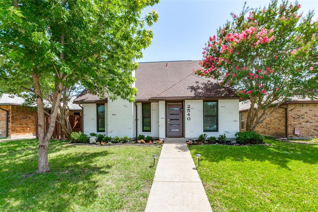 This beautifully updated home blends timeless style, thoughtful upgrades, and outstanding energy efficiency, making it as wonderful for entertaining as it is for everyday living. Lime-washed brick, tasteful landscaping, and warm curb appeal set the tone before you even step inside. A soaring vaulted ceiling, brick wood-burning fireplace, and gorgeous engineered hardwood floors create an airy, open flow perfect for hosting. Newly added recessed lighting brightens the living area and kitchen, where granite counters, a new sink and dishwasher, generous cabinet space, and a large walk-in pantry make gathering and cooking a breeze. The first-floor primary suite offers privacy from the secondary bedrooms, with a spa-like primary bath featuring a new double vanity, sleek frameless glass shower, and two walk-in closets. The guest bath also boasts a new vanity and fresh finishes. Recently replaced energy-efficient Andersen windows and steel front door flood the home with natural light, paired with new cordless shades throughout. Nearly every fixture and ceiling fan has been replaced, with new outlets and switches installed for a polished, move-in-ready feel. Step out to the covered back patio and into a whimsical, pollinator-friendly garden bursting with greenery, the perfect backdrop for morning coffee or evening barbecues. Efficiency shines here: solar panels cut monthly electric costs, while a smart thermostat, radiant barrier, and updated windows boost performance even more. The heat pump HVAC, installed in 2021, is serviced twice yearly. A floored attic offers ample storage, and custom closet systems keep the guest bedrooms organized. Both the front and backyards include extensive sprinkler and drip irrigation systems, including a dedicated foundation line for lasting protection. A durable Class IV impact-resistant roof (2020) completes this bright, breezy retreat. Come experience the love that has been poured into this home - you're likely to fall in love yourself!