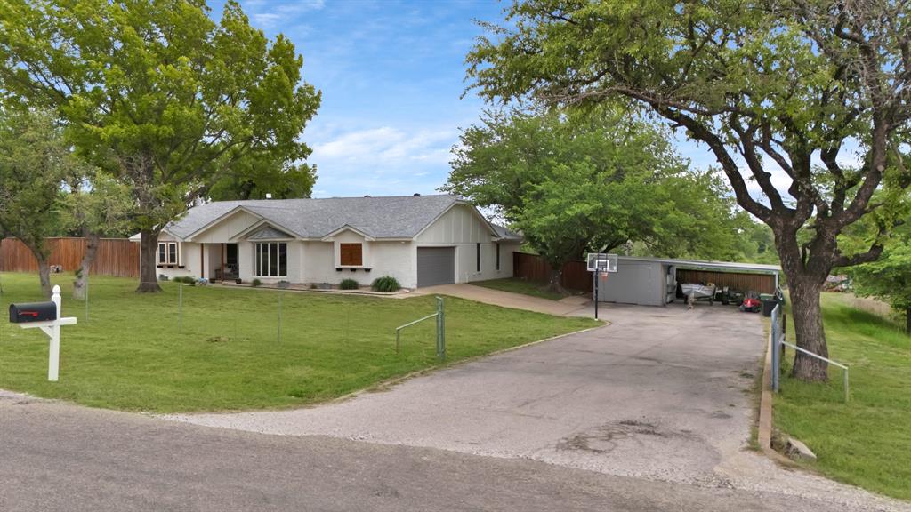 Discover a peaceful country retreat just minutes from Lake Weatherford, where quiet mornings, open skies, and natural beauty set the tone for everyday living. This beautifully updated 4-bedroom, 2-bath home offers modern comfort in a tranquil, private setting, where the backyard and deck provide quiet, neighbor-free views and room to relax, explore, and unwind.
Inside, natural light fills the open-concept living areas, highlighting the home’s modern-farmhouse finishes and warm, inviting atmosphere. The thoughtfully designed split-bedroom layout provides both comfort and privacy, while the spacious primary suite feels like a personal sanctuary—complete with dual barn doors, two walk-in closets, separate farmhouse vanities, and a newly remodeled walk-in shower.
Step outside and experience the kind of outdoor living that feels like a getaway. An expansive deck overlooks the in-ground Gunite diving pool, offering a perfect backdrop for summer gatherings, morning coffee, or peaceful evenings under the Texas sky. The property’s unique topography creates beautiful natural views, wooded pockets, and a sense of seclusion rarely found at this price point. Kids have enjoyed hiking, exploring, and turning the landscape into their own adventure space.
Practical features include a 2-car garage, carport, additional storage building, and a sprinkler system plumbed to the well. Major updates—roof (2021), interior-exterior paint, flooring, counters, lighting and plumbing fixtures (2020), water heater (2023), septic upgrades with above-ground cleanouts (2025), and gutters (2024)—provide peace of mind for years to come.
If you’re seeking quiet, comfort, and modern updates in a setting that feels private and restorative, this home delivers a lifestyle that’s truly hard to find—just 30 minutes from Fort Worth and moments from Lake Weatherford.