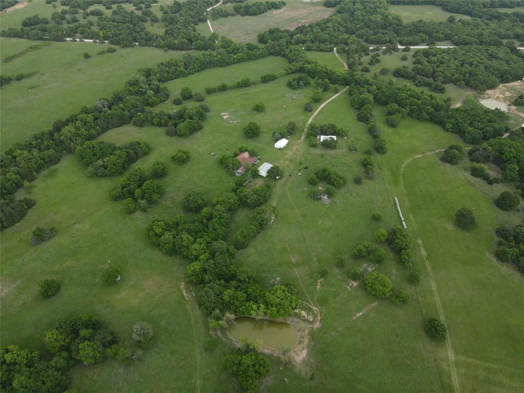 Escape to the country with this exceptional farmhouse estate on 160 acres in Bowie offering space, functionality, and breathtaking views. Currently under Ag exemption and set up for cattle, this property is ideal for ranching, recreation, or a private retreat with a seasonal creek running throughout. The main farmhouse is full of charm and complemented by an additional guest house perfect for extended family, visitors, or rental potential after some TLC. A 30x40 shop provides ample room for equipment, hobbies, or storage. Enjoy stunning landscapes, wide open skies, and the peace of country living while being just minutes from town. Property also is fenced with storm cellar for added security and peace of mind. Rare opportunity to own a versatile North Texas ranch with endless possibilities.