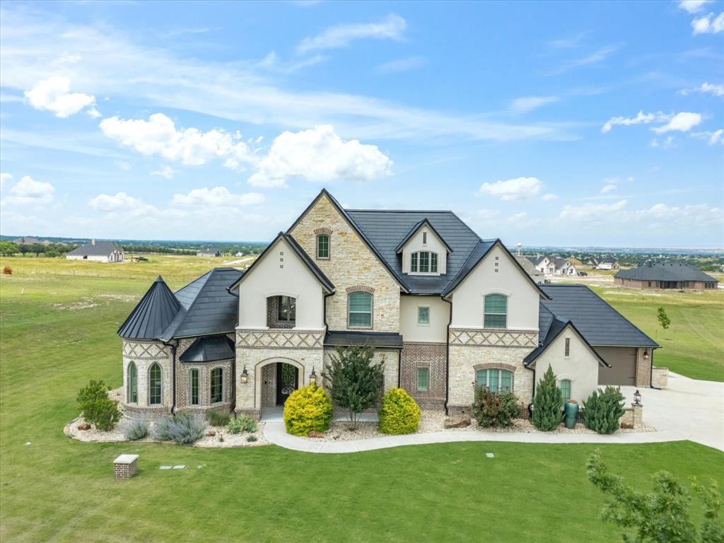Extraordinary European Country inspired home in one of the most desirable additions in Aledo -- La Madera Estates! Superbly built with perfect blend of sophisticated yet livable style and appointed from head-to-toe with gorgeous finishes and state-of-the-art amenities including TESLA Powerwall Backup Power Grid plus Class 4 rated TESLA Solar Roof Tiles — ultra energy efficient and arguably the most impressive feature of the home! Bright and open design chef's kitchen with SS commercial grade appliances, 6 burner cooktop and double ovens. The kitchen opens to impressive great room with high ceilings, impressive floor to ceiling stone fireplace, gleaming hardwood floors and great windows overlooking it's incredible resort-like backyard! Fabulous outdoor pool cabana with built-in BBQ grill and outdoor kitchen and living space overlooking a stunningly sleek pool with Pentair LED color lighting, pristine landscaping and gorgeous views of serene lake and pretty estate properties all around! Acclaimed Aledo ISD.