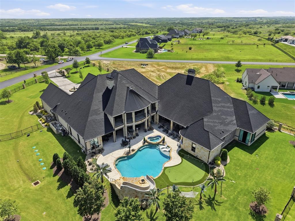 ***DO NOT REACH OUT TO SELLERS DIRECTLY***  This custom-built estate offers unrivaled features: almost 12,000 square feet of luxury and comfort blended to meet any and all needs for family, or entertaining, or relaxation, or active games and fun. The gated entrance is regal with iron and fencing, huge circular drive, parking for 6+ vehicles, fountain feature in the front, walk in to the floor-to-ceiling glass across the foyer bathing the formal living room with light and a view of your outdoor paradise, primary suite is downstairs, as is one other secondary bedroom, an office or gym space is downstairs, glass enclosed elevator, all bedrooms are ensuite and have walk-in closets, formal dining room is luxurious with vaulted ceilings and custom lighting, the kitchen is huge with island and built in commercial grade stove top and refrigerator, pot-filler, 2 dishwashers, granite and stainless with breakfast area boasting custom lighting, living room open concept with kitchen has warm stone fireplace and enormous TV area, doors out to patio and pool. Game room has 2-lane full-length bowling alley with all accoutrements and, full-size bar, pool table with all equipment, arcade games, tables for poker, leads off to separate enclosed movie room with projector and screen, comfy leather chairs, down the hall to the fully functional separate guest apartment (shares roof line and foundation, but off on its own for privacy), outdoor has approx 1200 sq ft of patio enjoyment area with built-in kitchen, putting green, waterfall in pool, specialty lights, chairs and tables and heaters all dotted along the way, so much more, a MUST SEE.   Please see all photos, aerials, interactive tour, floorplans , and all attached related documents.