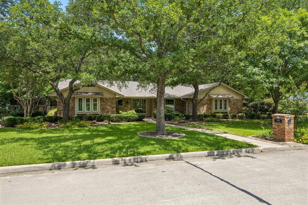 Nestled on a large lot in a quiet, secluded neighborhood, this beautifully maintained property offers a backyard retreat with mature shade trees, lush St. Augustine grass, a covered patio, & an in-ground pool & spa. Welcoming curb appeal invites you inside, where abundant natural light fills the open floor plan with hardwood & tile flooring throughout. The office features French doors, built-in desk & storage, while the living room offers a brick fireplace & beautiful backyard views. The updated kitchen features quartz countertops, bar seating, a bay window breakfast area overlooking the pool, & abundant custom cabinetry designed for maximum storage. The oversized primary suite includes space for a sitting area & an updated ensuite with double sinks & custom cabinets. All secondary bedrooms are generously sized. Two large bedrooms share a hall bath on the opposite side of the home, while a spacious fourth bedroom near the primary suite offers flexibility as a guest room, nursery, second office, or workout space. The utility room includes a sink, extensive storage, access to the attached single-car garage, & direct access to the pool area. A third full bath is located just off the utility room, providing convenient access from the backyard. Additional features include a safe room, tankless water heater, water softener, & abundant storage throughout. The detached 28' x 22' garage offers extensive cabinetry, a woodworking exhaust system, & covered 28' x 13' rear storage with electricity, in addition to the attached single-car garage. Updates include kitchen & bath renovations (2018), Class 4 roof (2024), diving board, interior paint, molding, light fixtures, ceiling fans, & sprinkler system (2025). Located in the highly sought-after Grapevine-Colleyville ISD, this exceptional property offers the perfect blend of privacy, outdoor living, & everyday convenience.