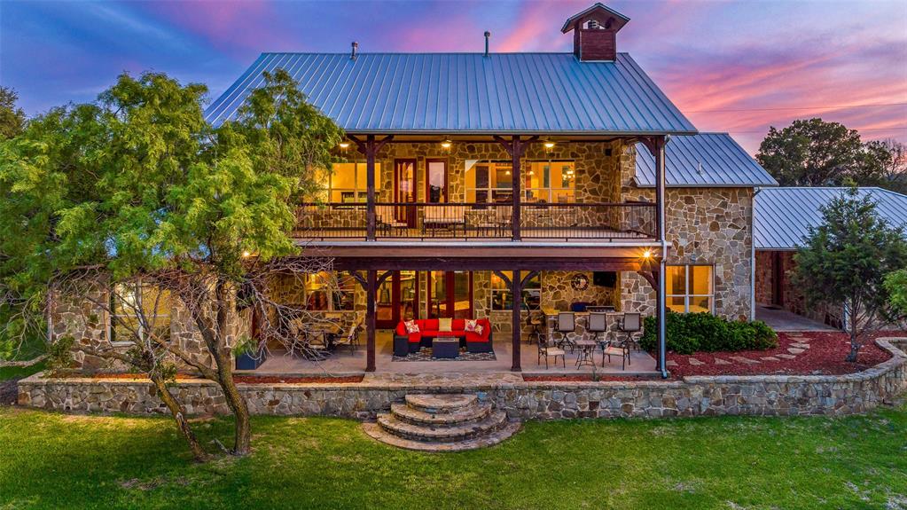 Welcome to your own private oasis located in the highly desirable neighborhood of Gaines Bend on Possum Kingdom Lake. A stunning 5 bedroom, 3 and a half bathroom 2-story ranch-style fully furnished home. As you step inside, your're greeted by a spacious and open floor plan that seamlessly blend the living, dining, and kitchen areas with a stone fireplace and large windows for views of the lake. Beautifully furnished interior, complete with plush new carpeting and high-end finishes throughout. Upstairs features a second living room and access to the balcony overlooking the lake. Outside, there's plenty of space for entertaining with outdoor kitchen and covered patio. Take a stroll down to the boat dock and enjoy a day on the lake, or simply relax and take in the stunning views. With a spacious 2-car garage with porte cochere and plenty of room for storage, this home has everything you need for comfortable living.