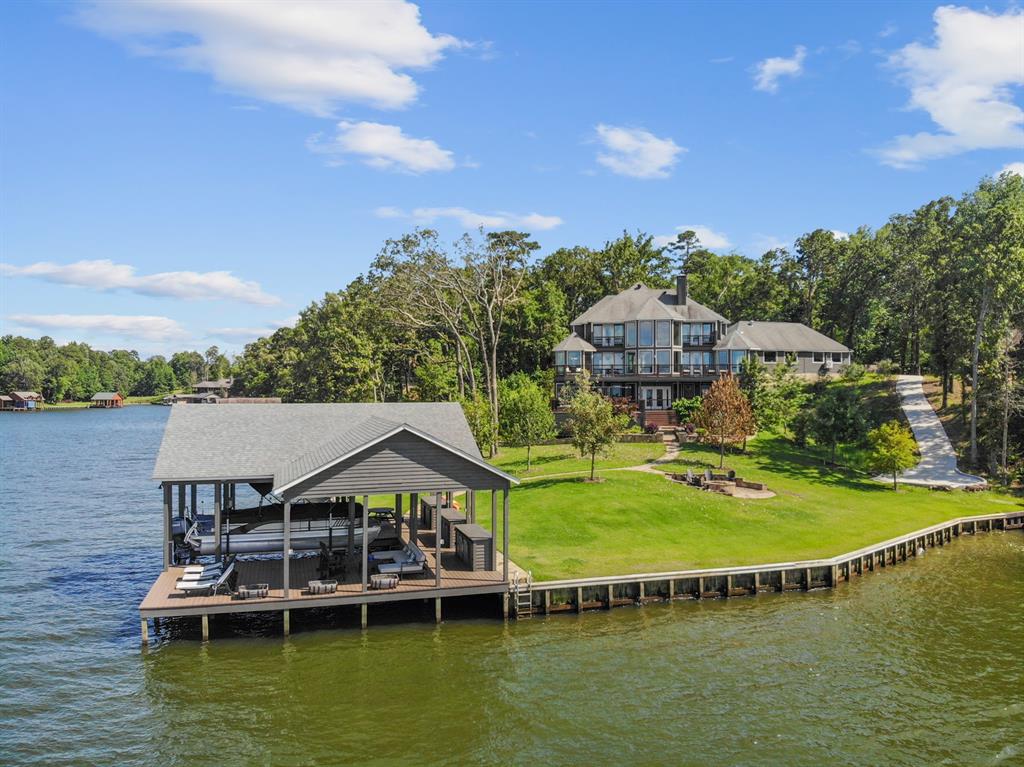 Majestic Lake Cypress Springs waterfront property in coveted El Dorado! Fully upgraded & remodeled, the 5,200+ sqft home was taken to the studs with no expense spared to offer captivating panoramic main-lake views. With premium finishes throughout, the home is adorned with oil rubbed wood floors, marble & quartz countertops, & recent floor to ceiling windows. The main level with its grand ceilings & fireplace, gourmet kitchen with top of the line Wolf & Sub-Zero appliances, guest suite, & luxurious primary suite with its sitting area & spa-like ensuite. Upstairs features an additional bedroom & guest suite with private ensuite & balcony. The lower level's living, 2nd full kitchen & dining, bed & ensuite offer a retreat unlike any other. Expansive balconies & patios create seamless indoor-outdoor entertainment that transcends the home's 3 levels with the lower level's newly integrated state of the art Masterclass SwimSpa that doubles as a workout pool then flows gradually down the flagstone walkway to the open water. The near 2 acre property is on 3 full waterfront lots (the third of which could be built on) with retaining walls and upgraded landscaping. Additionally, this property offers a 5 car garage, golf cart pathway for easy access to the water & amazing boathouse with the max amount of storage for boating and outdoor toys and accessories. This is a true legacy property on beautiful Lake Cypress Springs. Additional photos coming soon!