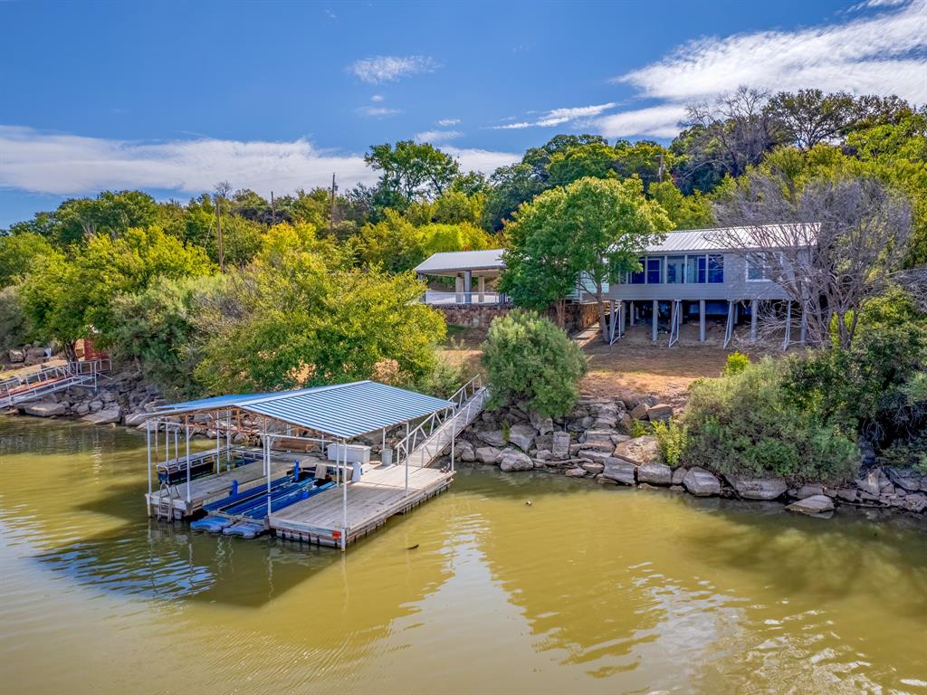 Your Lake House Awaits! This stunning, fully-furnished waterfront retreat could be your next great investment.

The main home spans 1,026 sq ft of beautifully designed open concept living. Large windows and French doors frame breathtaking lake views from nearly every angle. Both bedrooms include spacious walk-in closets, and the primary suite offers direct access to a 184 sq ft enclosed deck, the perfect spot for guests to unwind and soak in those unforgettable sunset views. 

The studio-style guest unit adds another 338 sq ft of private accommodation complete with a walk-in closet, full bath, and its own 146 sq ft private deck overlooking the water. Picture warm summer evenings on the deck, golden sunsets melting over the water, and the kind of quiet lakeside magic the water invites. Major improvements completed in the past 12 months include metal roofs on both structures, updated decks, fresh siding, new windows, upgraded insulation, foundation leveling, a covered entry, new fencing, and more. 

This property is truly move in or rent out ready.