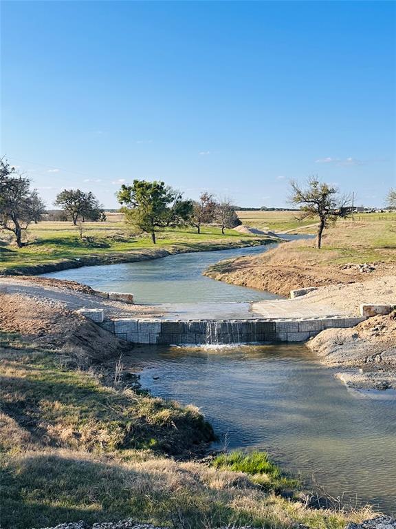Experience the charm of a bygone era on this stunning 265 acre, LIVE-water ranch. Situated at the top of the hill country on the Bosque and Hamilton county line. Norwegian settlers arrived in Texas in the mid-to-late 1800s, establishing their families in the picturesque area of Cranfills Gap. The main residence, a beautifully restored 1880 Norwegian two-story home, boasts four bedrooms, three full bathrooms, and two half-bathrooms. Ample space for entertaining is provided by two dining areas, two living areas, a spacious covered rear patio, and superb wraparound porch. This historic home makes a striking impression as it welcomes visitors to the beautiful Goar Valley. The crystal-clear waters of Neil's Creek flow gently through the rear half of the property, creating opportunities for wildlife observation and hunting. Multiple stock tanks are scattered along the front half of the property with a set of flood control dams in place along the waterway. The property is fully fenced and cross-fenced, with separate grazing areas featuring improved pastures of Klein grass and King Ranch Bluestem, as well as award winning coastal Bermuda hay. The expansive ranch offers possibilities for multi-generational living or rental income, including two additional residences. The second home is positioned among a beautiful oak grove. This home is a 3 bed 2 bath, separate carport and separate gated entry onto the ranch, making renting a breeze. For ranch guests or family members seeking seclusion, the third dwelling presents an ideal retreat, boasting a 1200 square foot loft apartment that includes a full kitchen and living area. Recent upgrades have been completed, and a detailed list is available for each residence. Additional outbuildings include the original barn, a large hay barn, equipment shed, and metal shop. This property is equipped with a well in addition to coop water service with Mustang Valley Water. Mailing address is Clifton, Tx. Owner is a licensed real estate broker