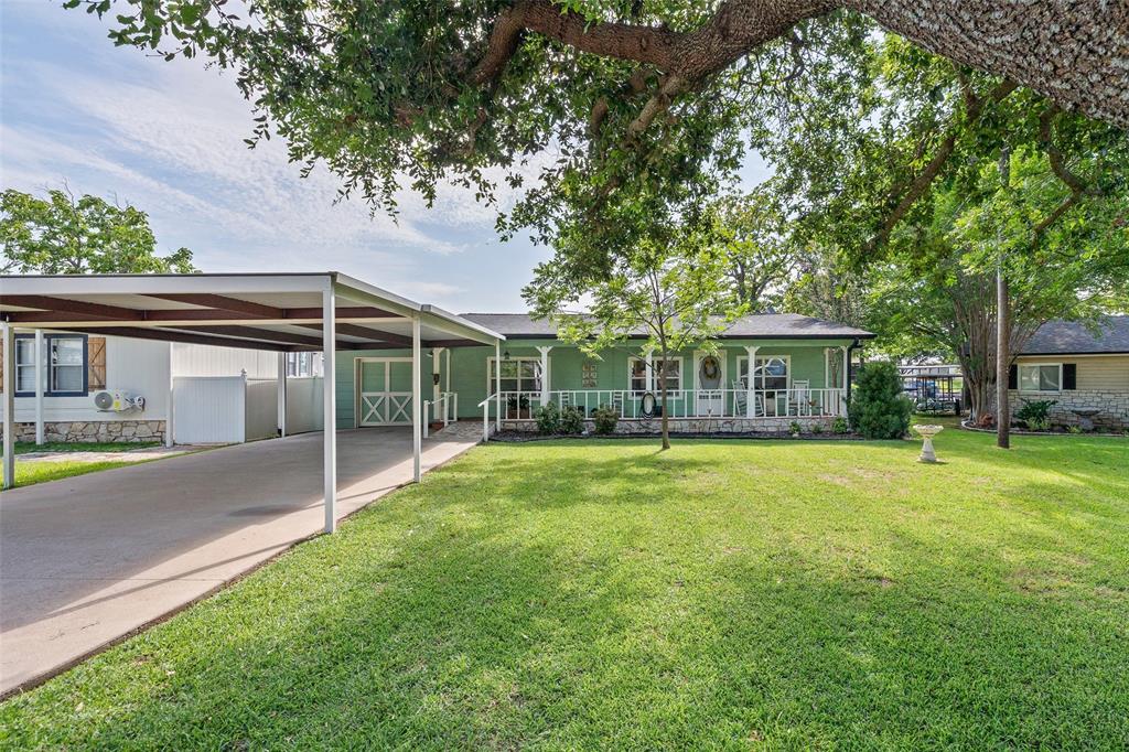 Experience waterfront living on Lake Granbury in one of the few affordable communities on the desirable north side of the lake with an easy commute to Fort Worth. Situated on a quiet canal with expansive views of the main body, this property offers the best of both worlds—protected water for your boat and breathtaking open-water views.

This well-maintained 3-bedroom, 2.5-bath home features a split-bedroom floor plan, an updated kitchen, and an open-concept living and dining area designed for entertaining. The light, airy interior showcases a relaxed lake-house aesthetic that perfectly complements the waterfront lifestyle.

Enjoy the outdoors from both the covered front porch and covered back porch overlooking the level, grass-covered, fully fenced yard. Whether you're hosting family and friends or relaxing after a day on the lake, there's plenty of space to enjoy.

The private boat dock with lift provides quick access to boating, fishing, and water sports while keeping your boat protected in the calm canal. A golf cart-sized garage offers convenient storage for your cart and lake toys, with additional space in the rear for a workshop, hobbies, or extra storage.

Whether you're looking for a full-time residence or the perfect weekend getaway, this home offers exceptional value, beautiful waterfront views, and easy access to everything Granbury has to offer. Home has already been moved to city sewer system.