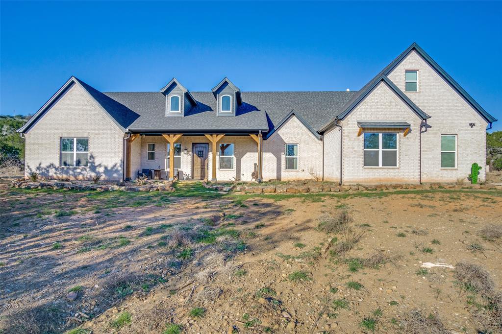 If you're searching for an absolutely stunning ranch home with the perfect blend of modern convenience and serene privacy, this property is a must-see. Located on the peaceful Brazos Mountain Ranch, this gated, wooded retreat feels like a world of its own. Built in 2022, this custom home exudes timeless charm and stylish contemporary touches from the gourmet kitchen and thoughtful, open floorplan to the incredible five wooded Ag Exempted acres where exploration awaits. Featuring tasteful finishes throughout, you'll love entertaining and hosting weekend getaways with family and friends. The home chef will be delighted to find a side-by-side stainless refrigerator freezer combo, granite apron sink, pendant lighting, built-in oven, microwave, copious amounts of cabinetry, open shelving and a large kitchen island with plenty of counterspace for preparing culinary masterpieces. A generously sized walk-in pantry lies adjacent to the kitchen as does the separate laundry room. The living room will surely bring everyone together. Whether it’s relaxing with good reads or gathering around the fireplace, you will love the warmth and sophistication this home offers. The dining area is adorned with a striking modern chandelier that is truly a conversation piece. The primary bedroom and ensuite bath is the perfect retreat for beginning and ending the day with gorgeous marble flooring, dual wooden vanities, designer lighting, fixtures and two generous walk-in closets. A separate shower with dual showerheads takes it to the next level. The second and third bedrooms share a full bath with hex-tile flooring, double vanity and walk-in shower with crisp white subway tile. The fourth bedroom has an walk-in closet and bath that is softly adorned in pink and brushed gold. An additional bonus room and bathroom complete this functional floorplan. Watch the sunset or grill your favorite food from the covered porch and flagstone patio. You'll love the breathtaking vistas in all directions!